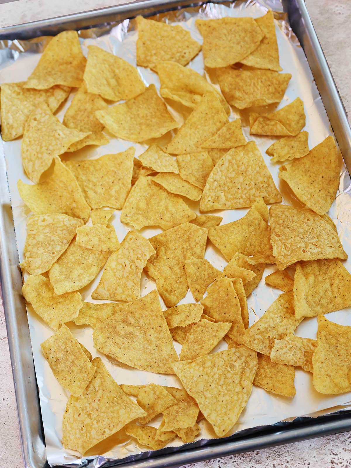 first layer of chips on tray for oven baked nachos.