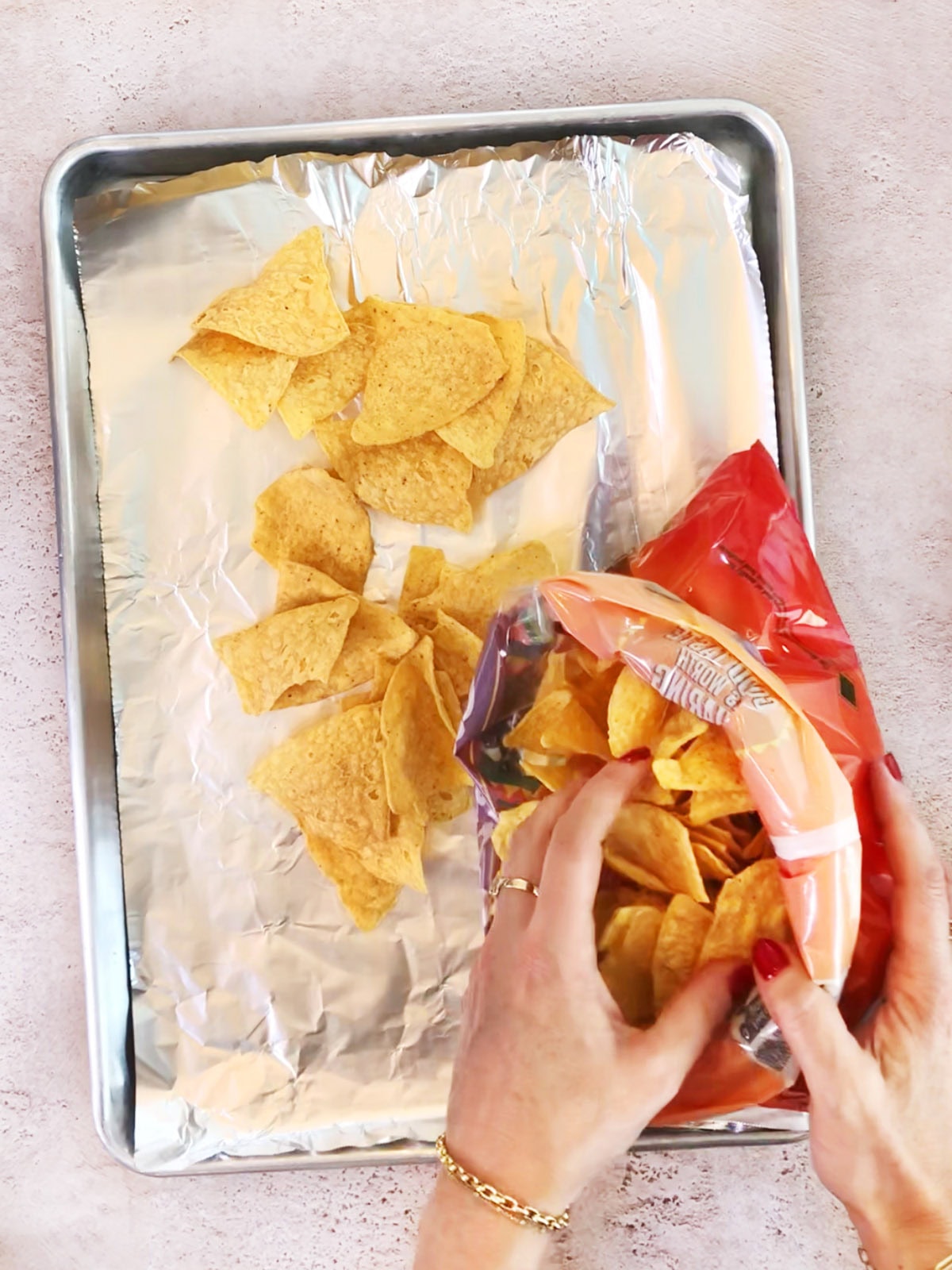 how to step placing chips on a foil lined baking sheet for oven baked nachos.