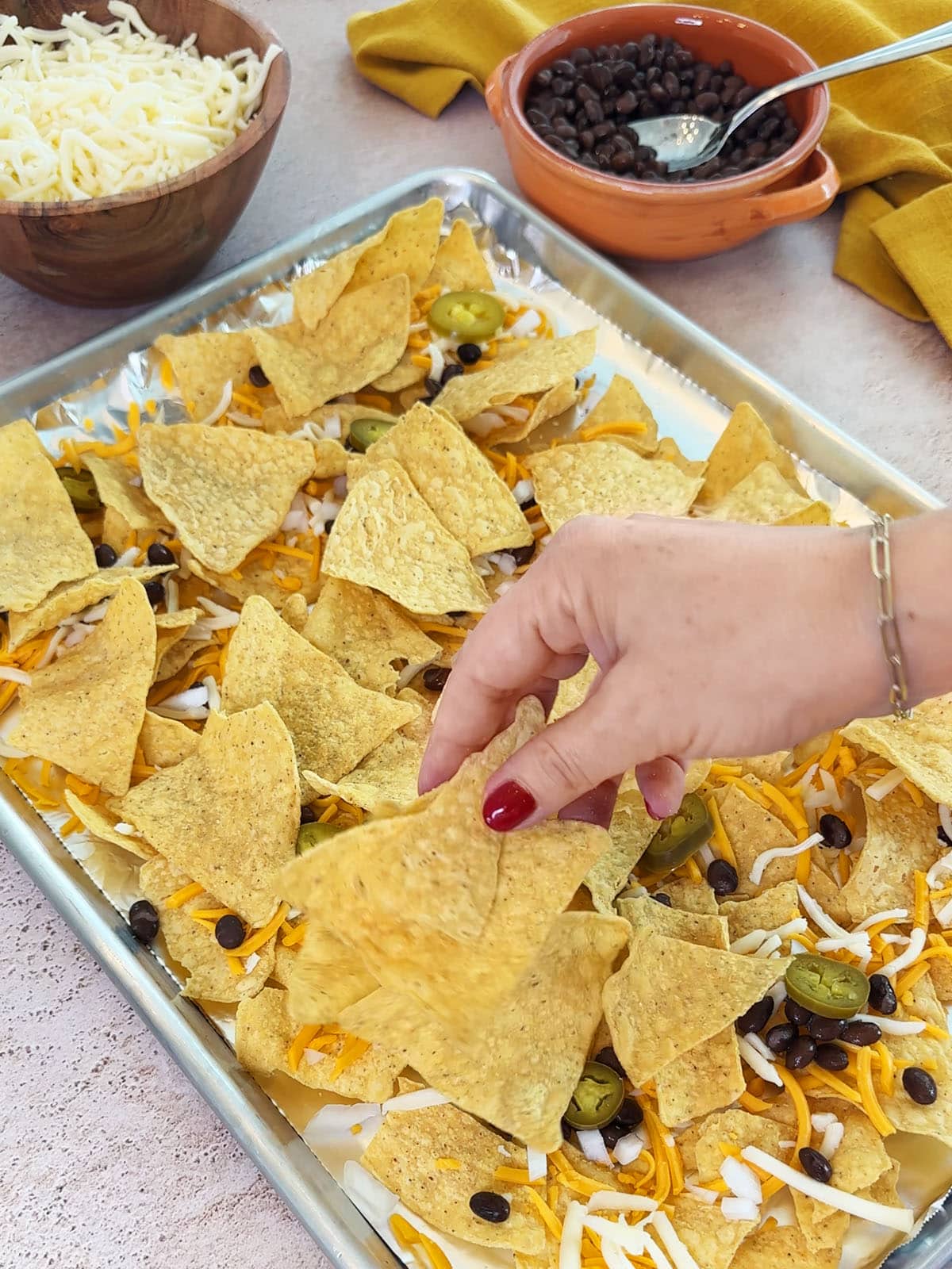 adding second layer of chips on top of first layer for nachos in the oven.