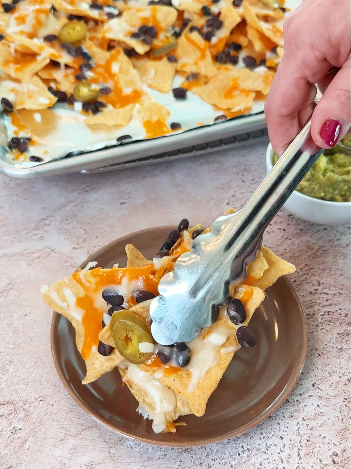 serving baked nachos on a single serving plate.