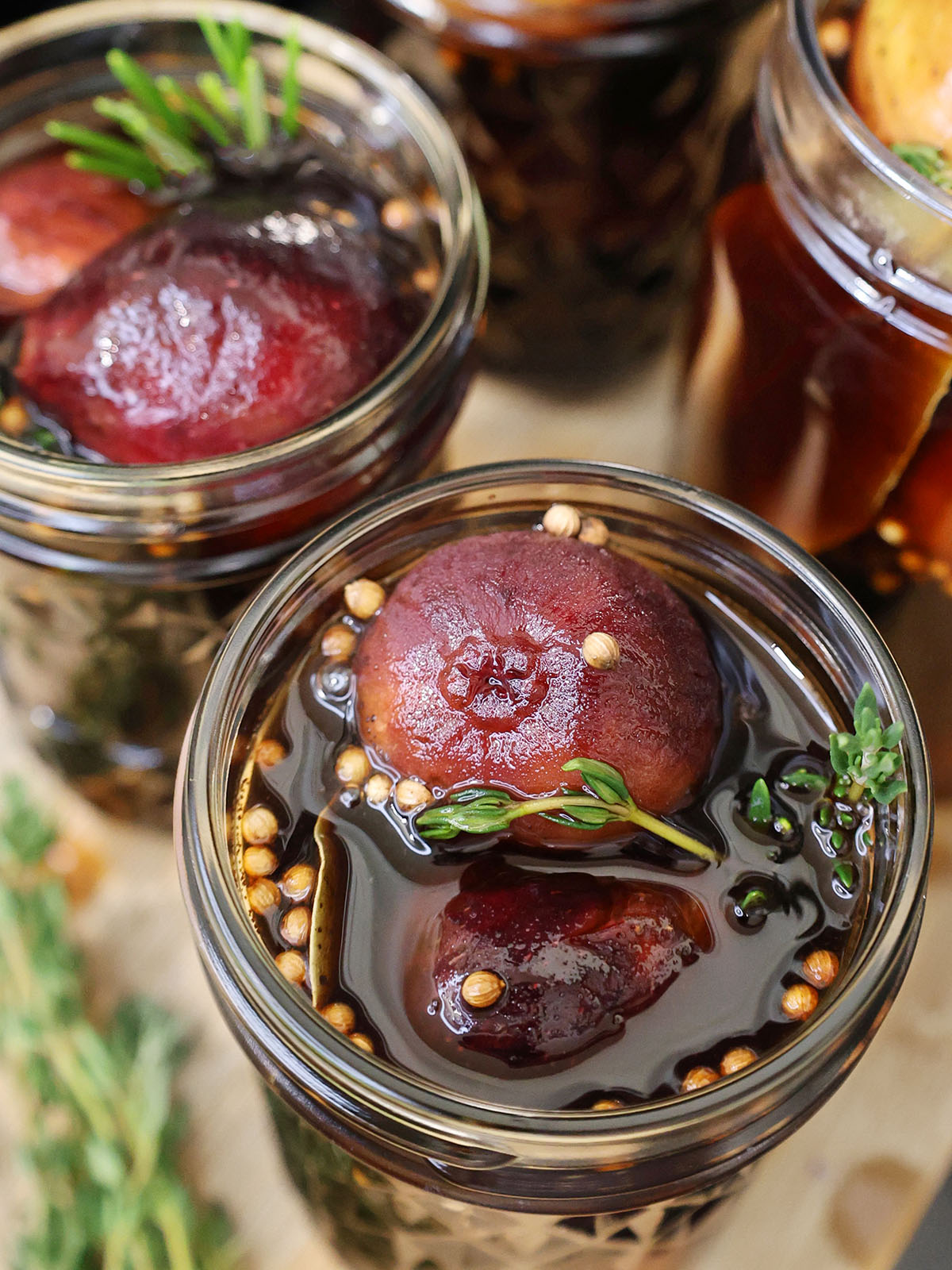 close up of preserved figs in jars with spices and herbs to see texture.