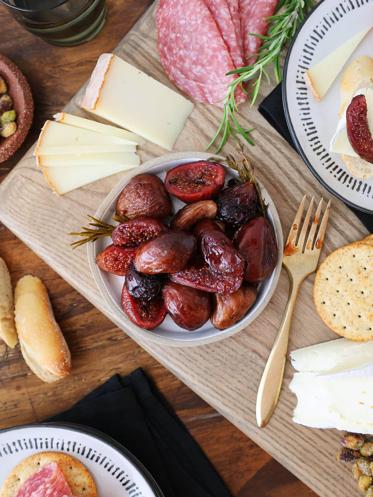 plate of preserved figs on a cheese board with charcuterie.