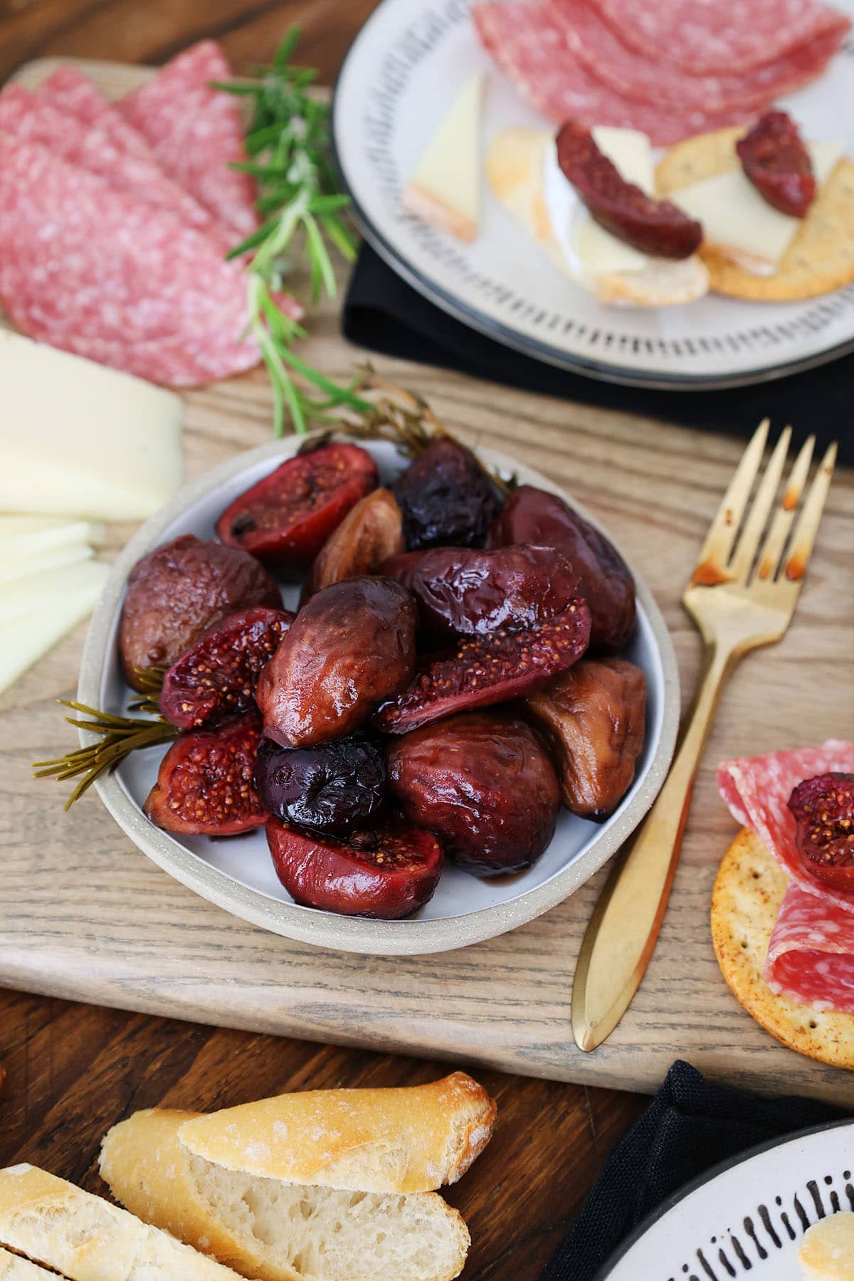 close up of preserved figs on a plate with charcuterie and cheese.