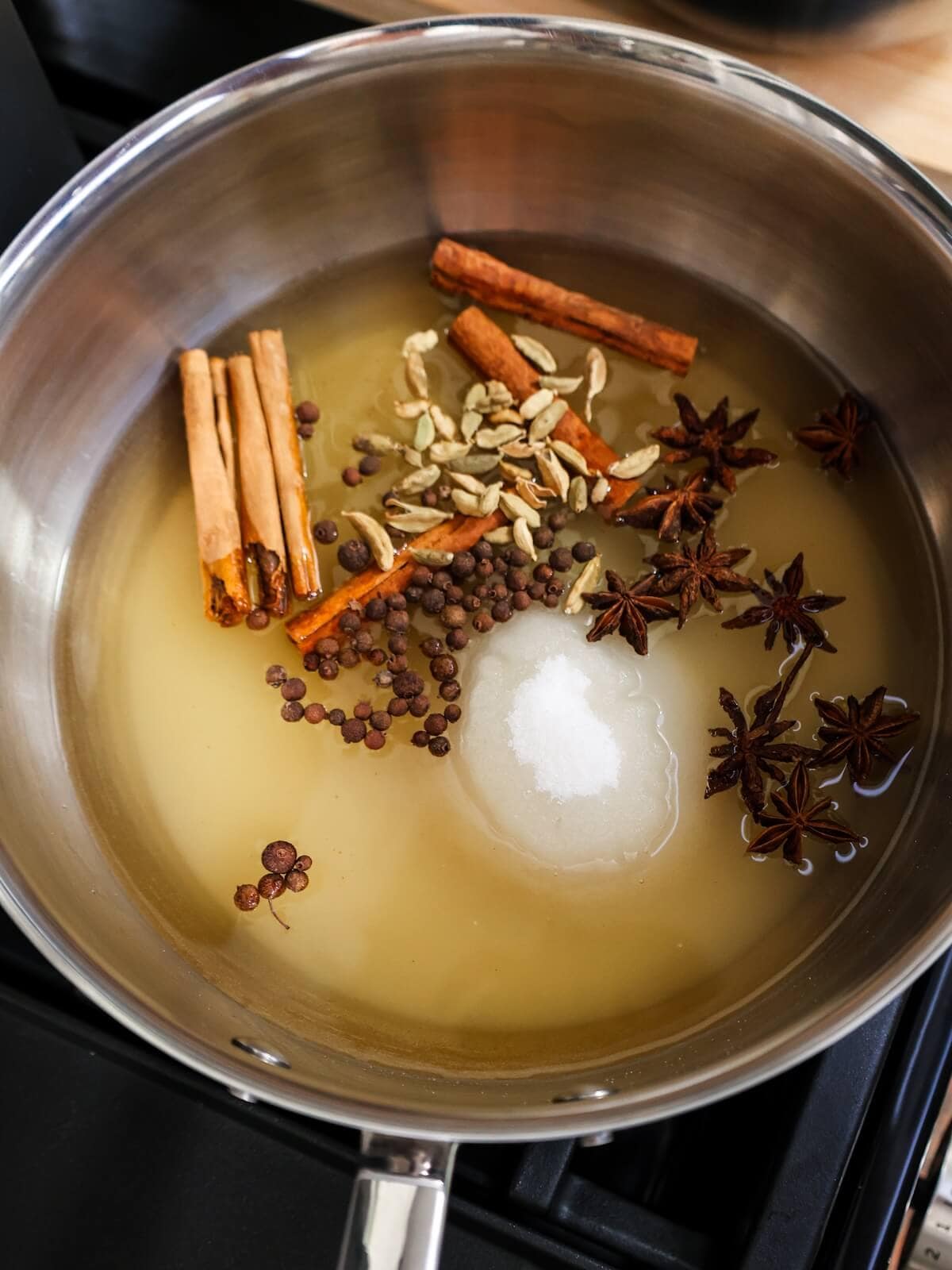 making simple syrup in a saucepan with spices for preserved figs