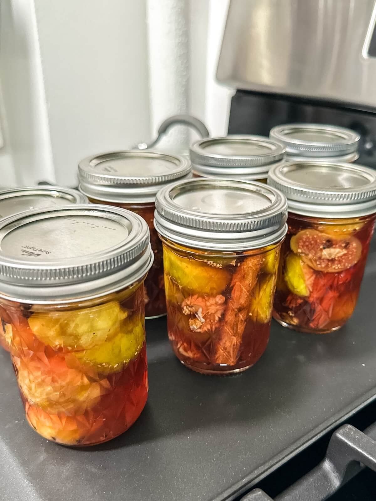 letting rows of jarred figs and syrup cool off to seal the jars for preserving.