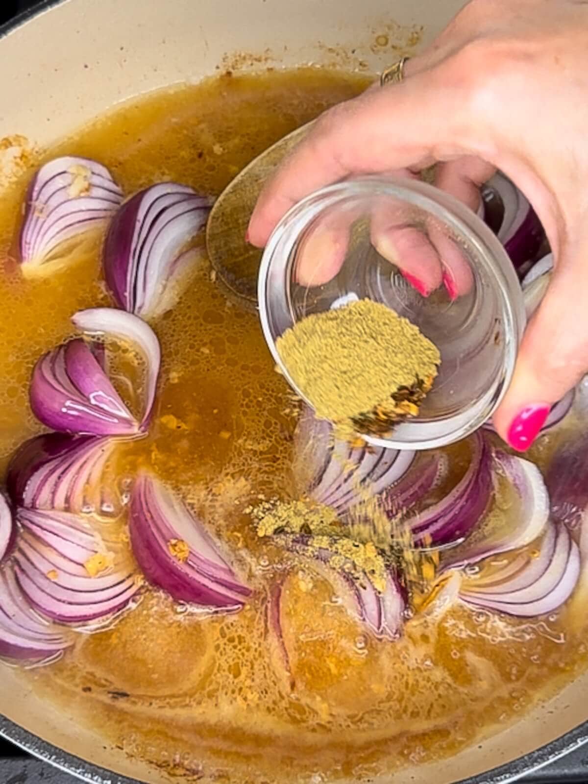 adding spices to figs and chicken sauce with red onions.