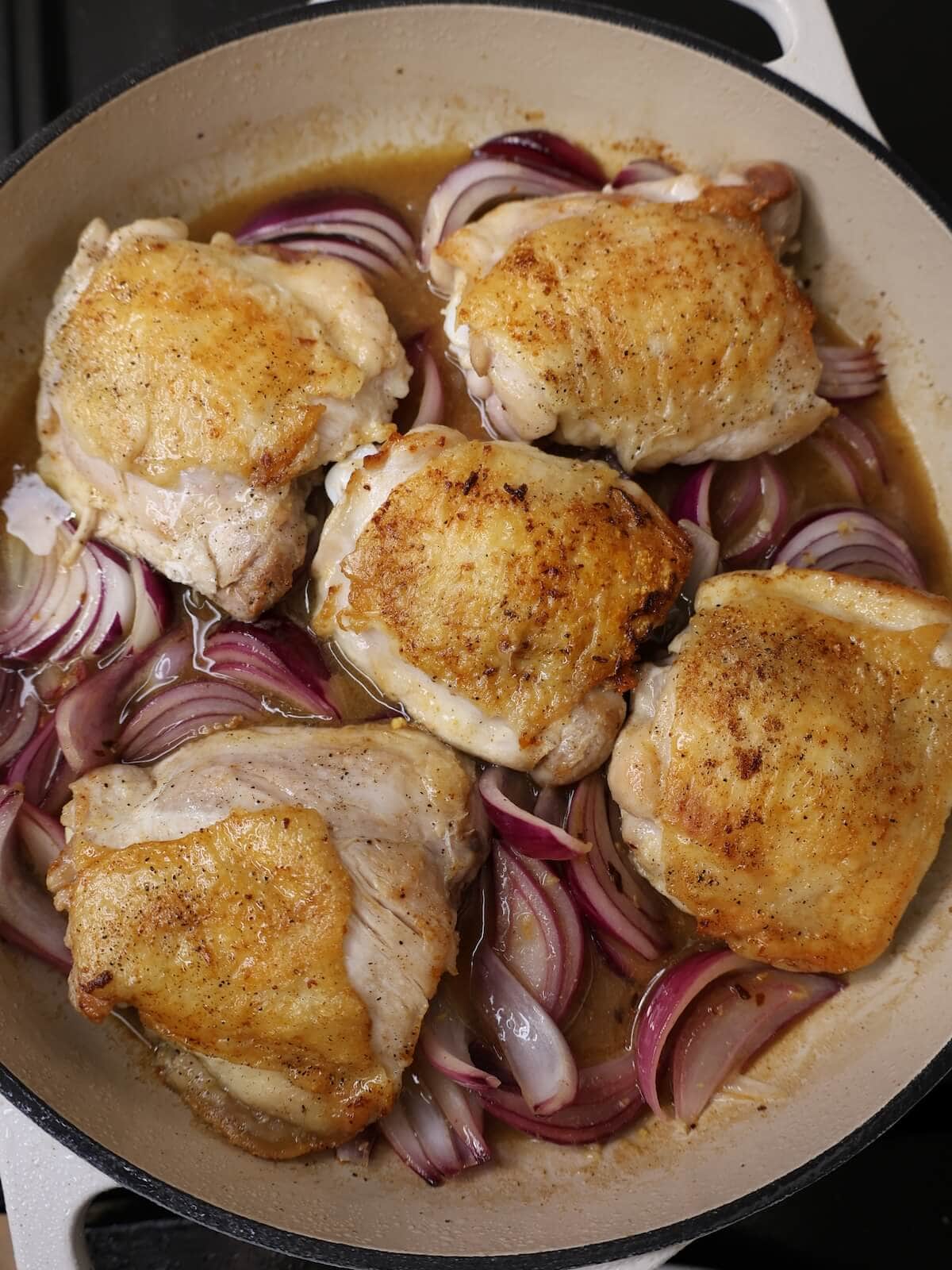 chicken thighs and onions in a skillet for figs and chicken.