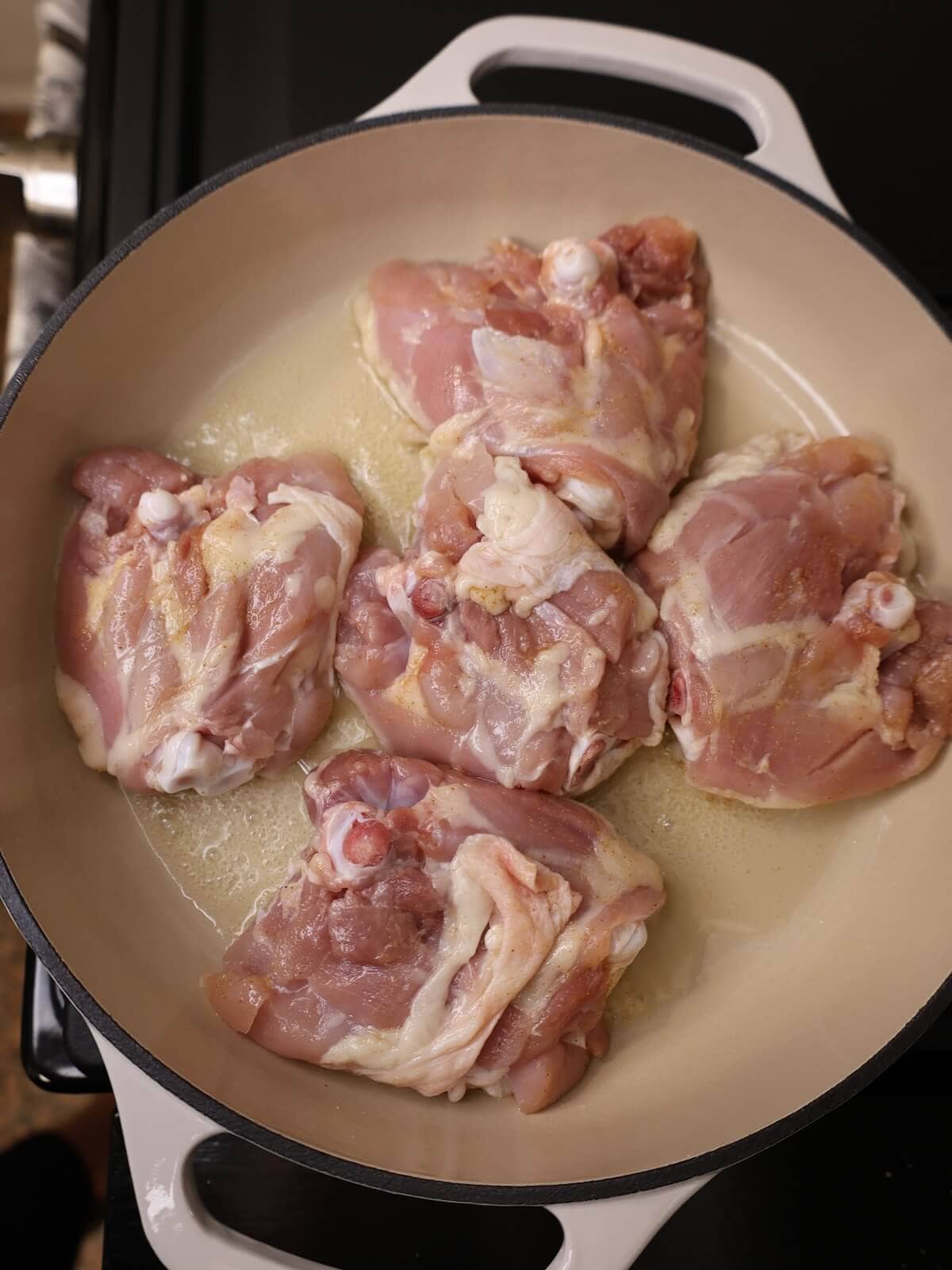 cooking chicken thighs skin side down in a large skillet