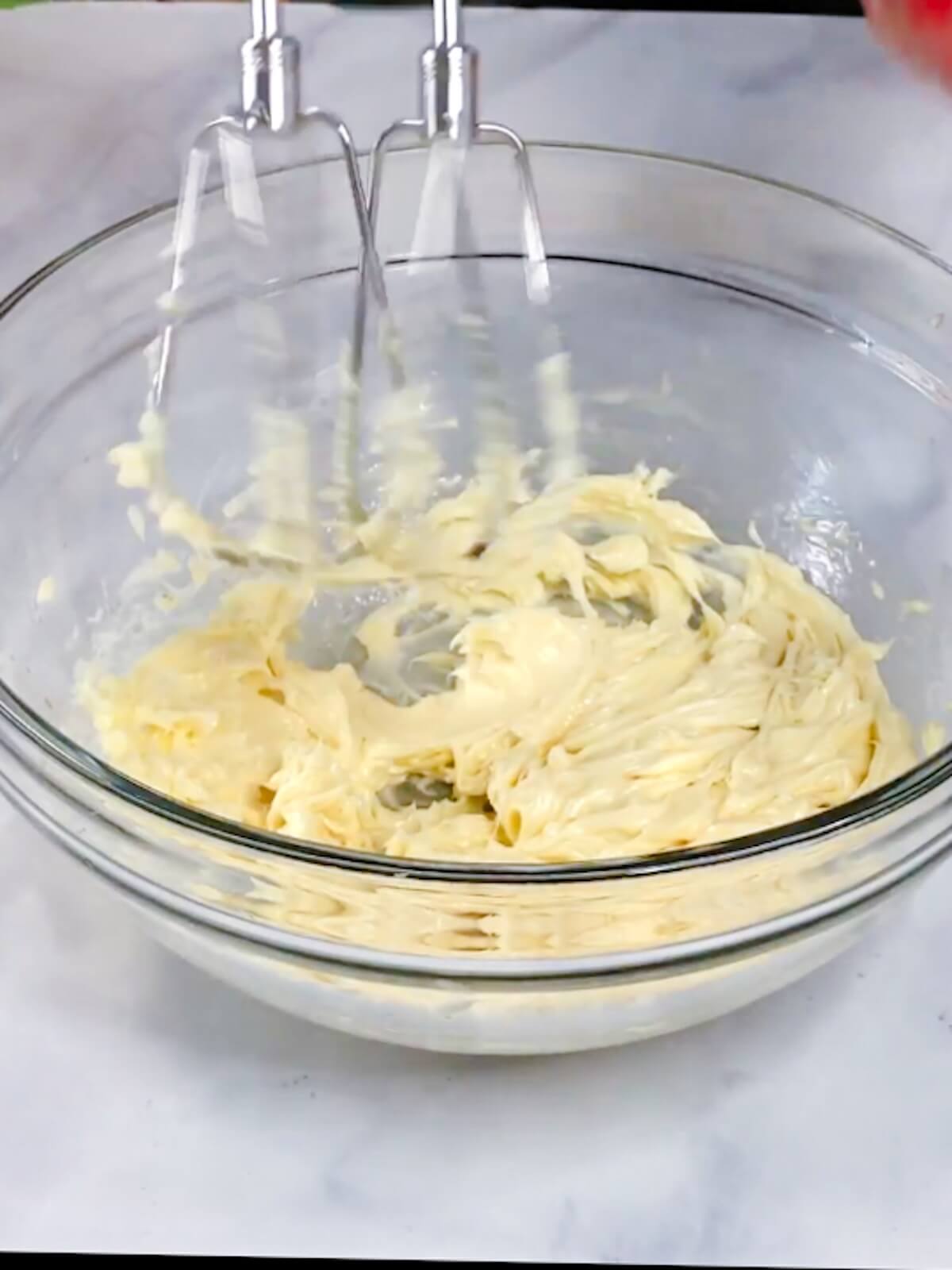Using a hand mixer to beat butter and vanilla.