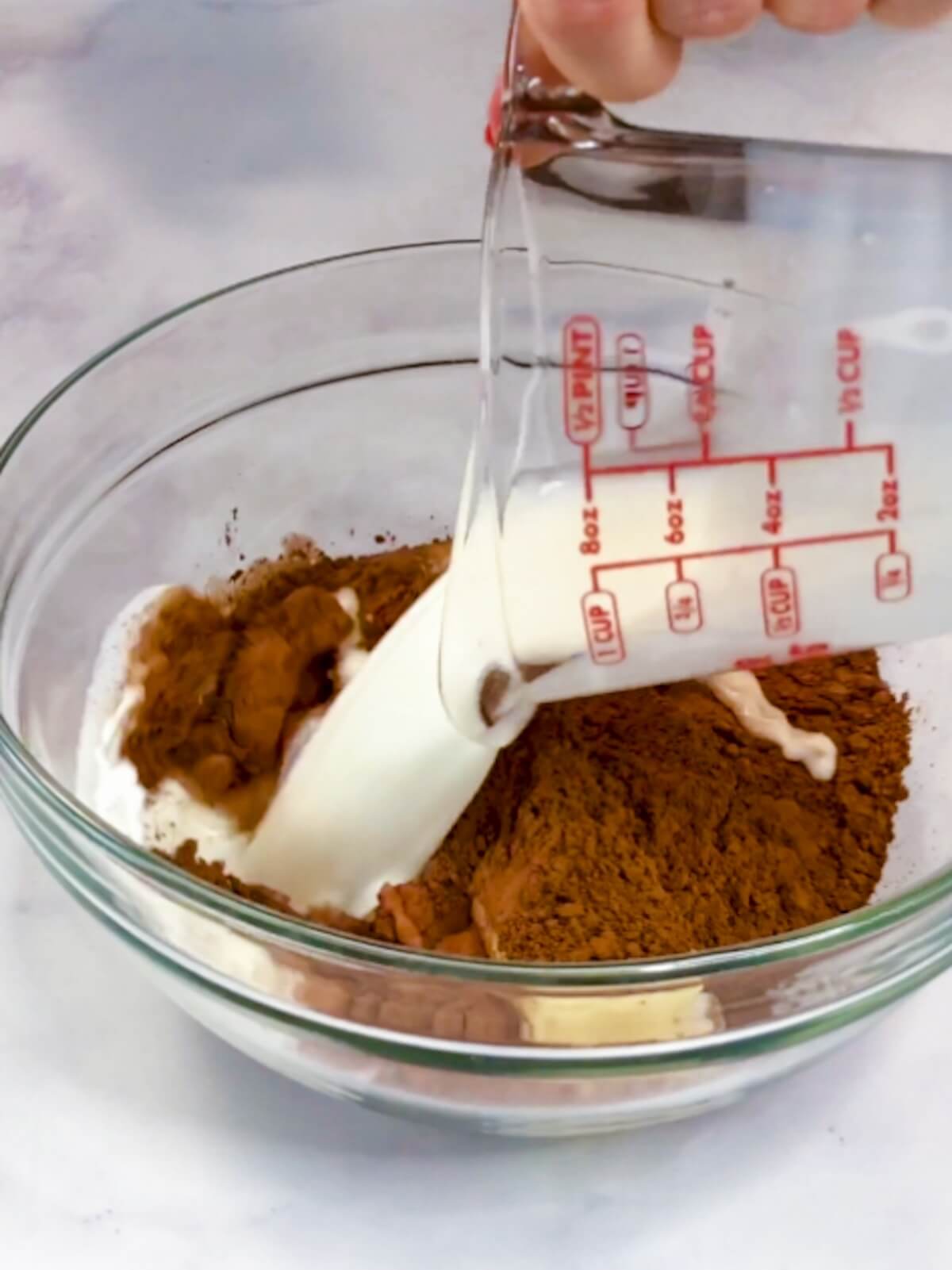 Adding milk, butter, and cocoa powder to a bowl..