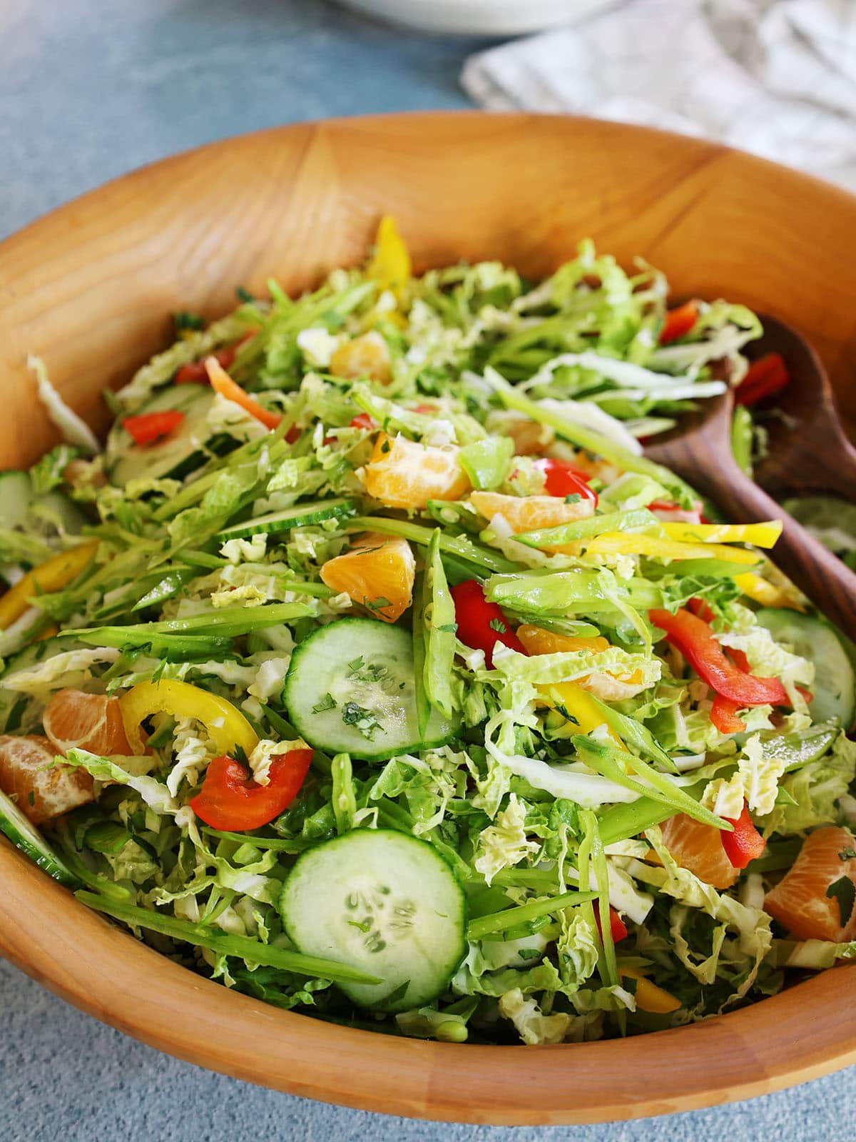 asian salad with oranges and snow peas tossed in a bowl.
