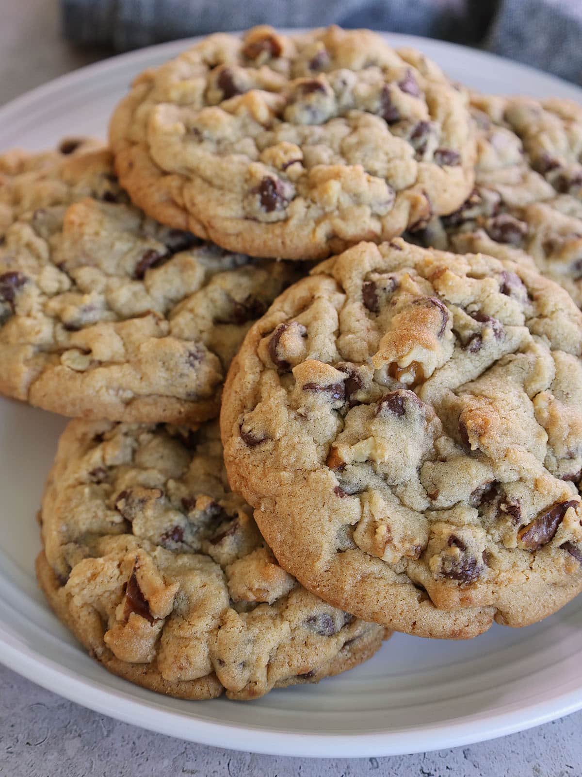 walnut chocolate chip cookies piled on a plate.