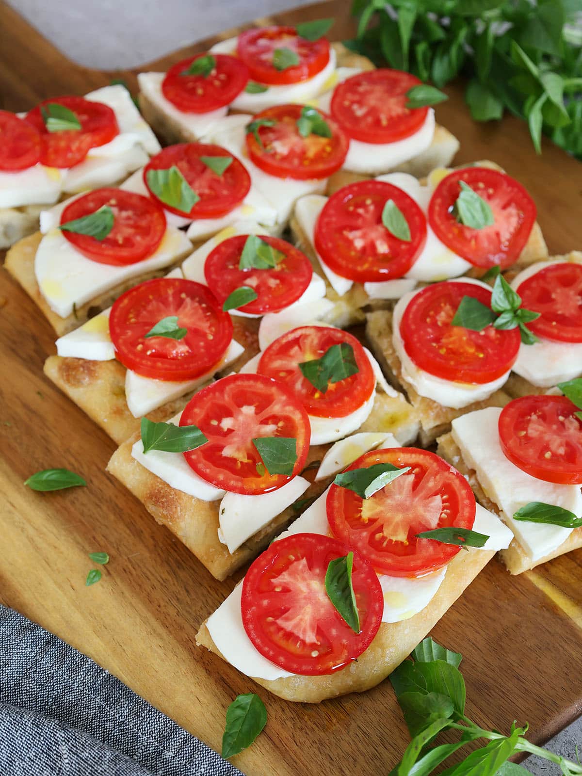 caprese focaccia on a cutting board ready to serve.