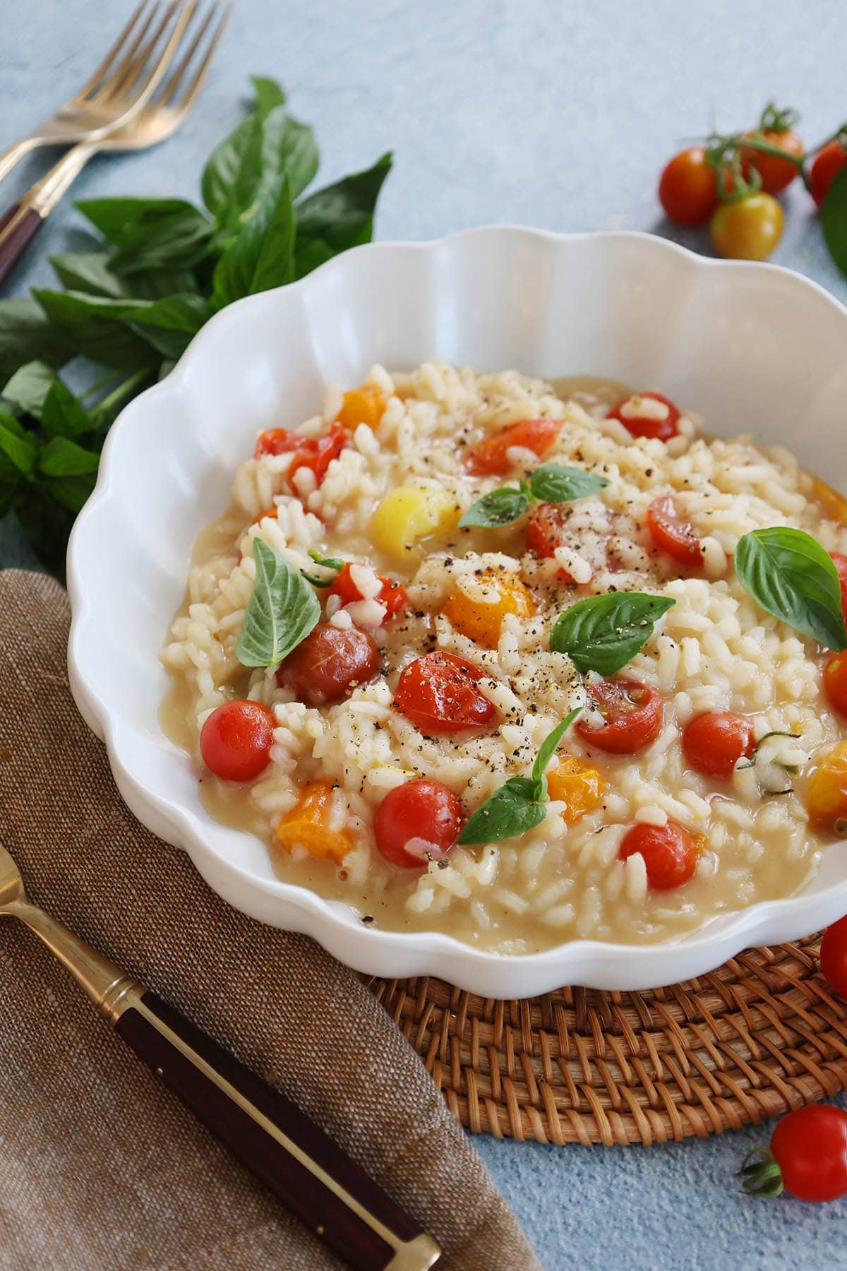 bowl of cherry tomato risotto with basil and cracked pepper.