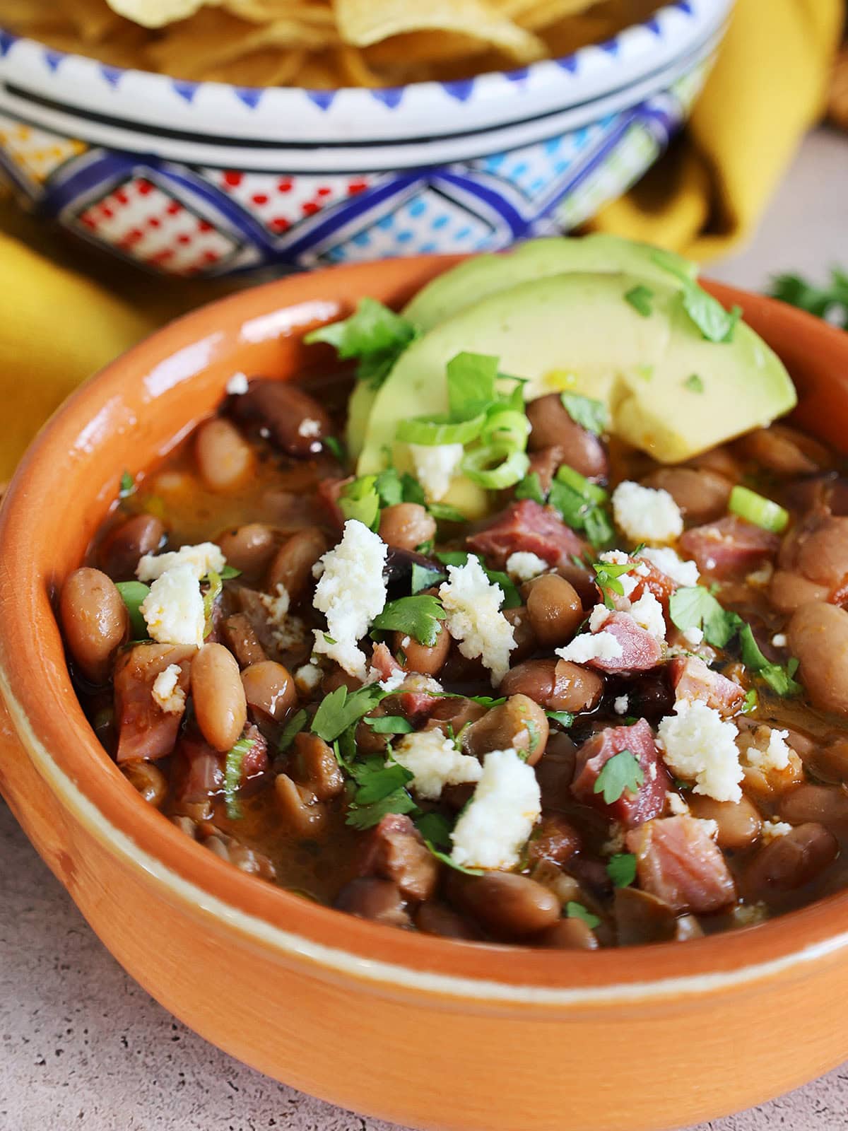 close up of bowl of frijoles charro with cotija