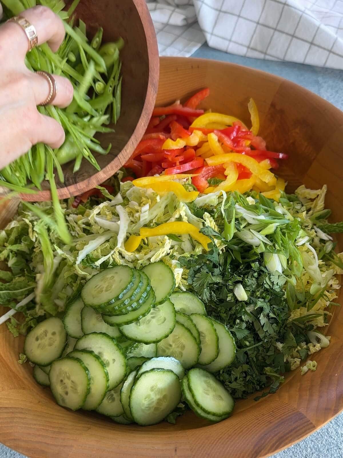 Combining all the chopped vegetables in a bowl for asian slaw.