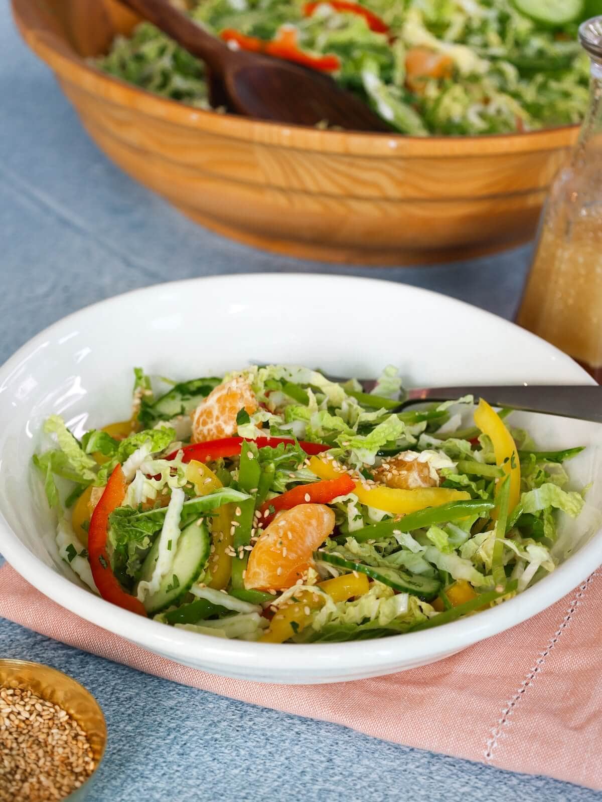 Serving of asian slaw with sesame dressing in a white bowl