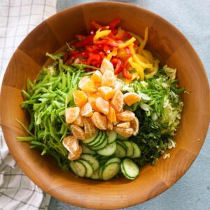 feature of asian slaw salad in a wood bowl.