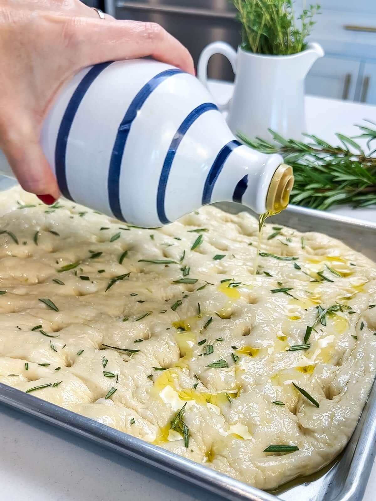 drizzling oil on focaccia dough before baking.