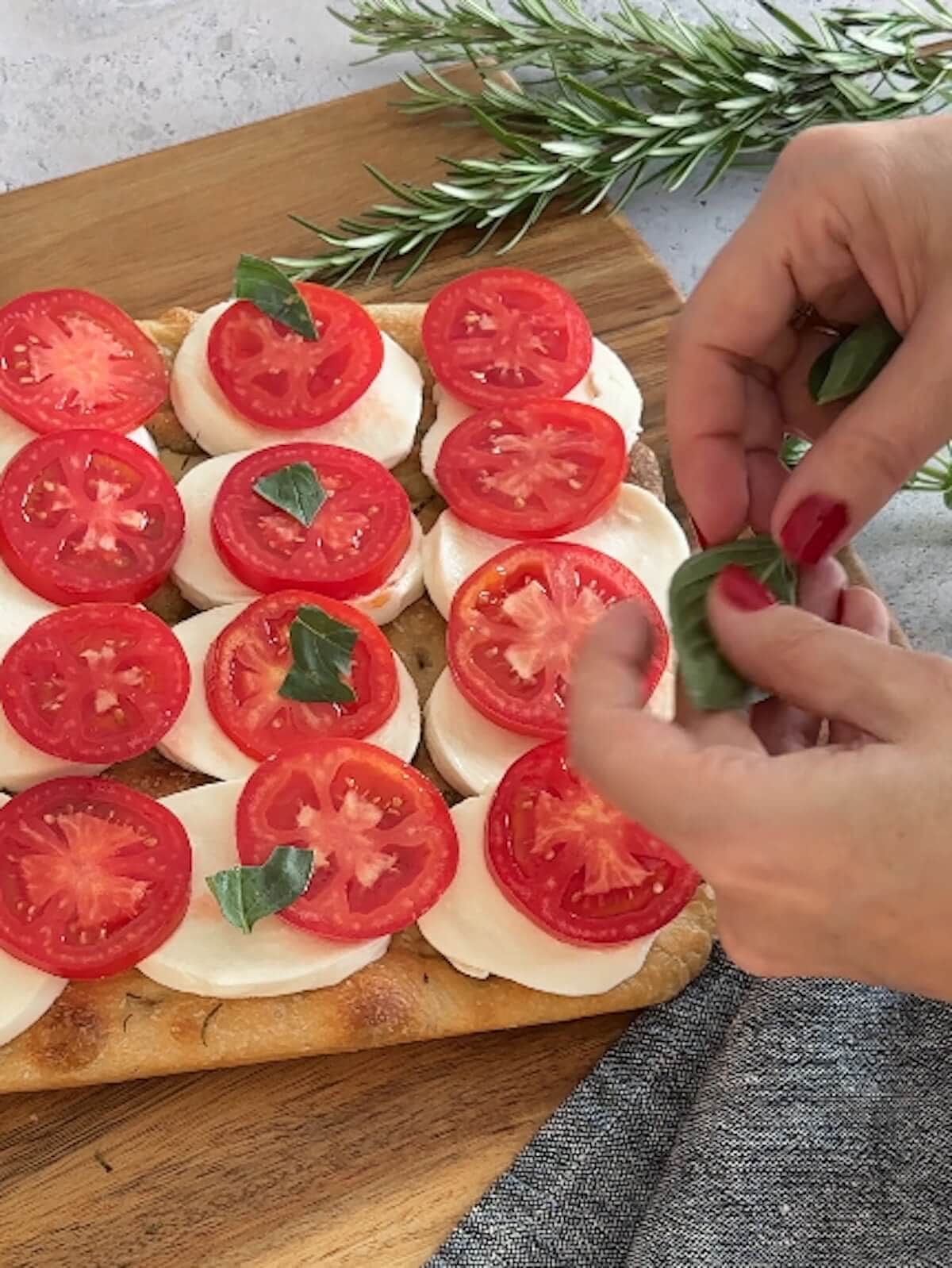 placing basil on caprese focaccia