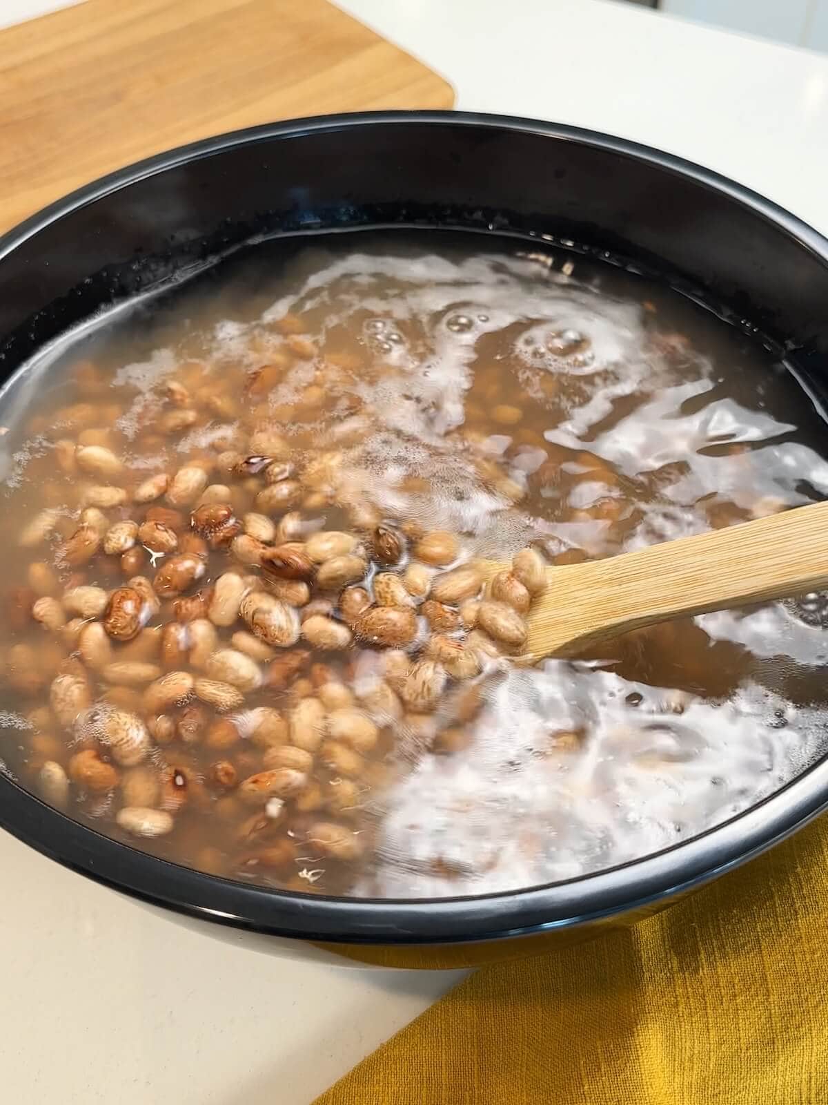 Soaking pinto beans in water for 8 to 10 hours.
