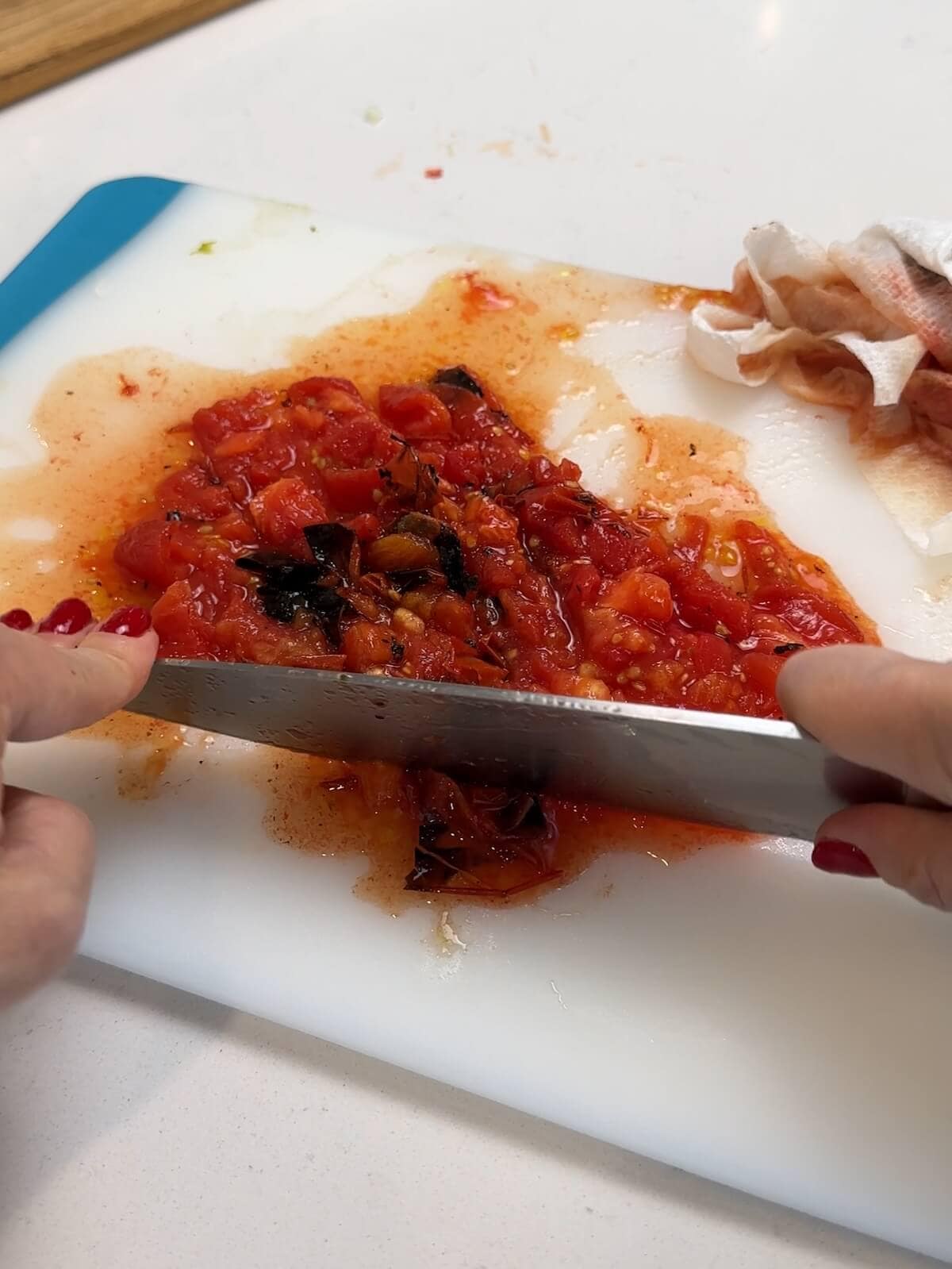 chopping charred and seeded tomatoes for charro beans.