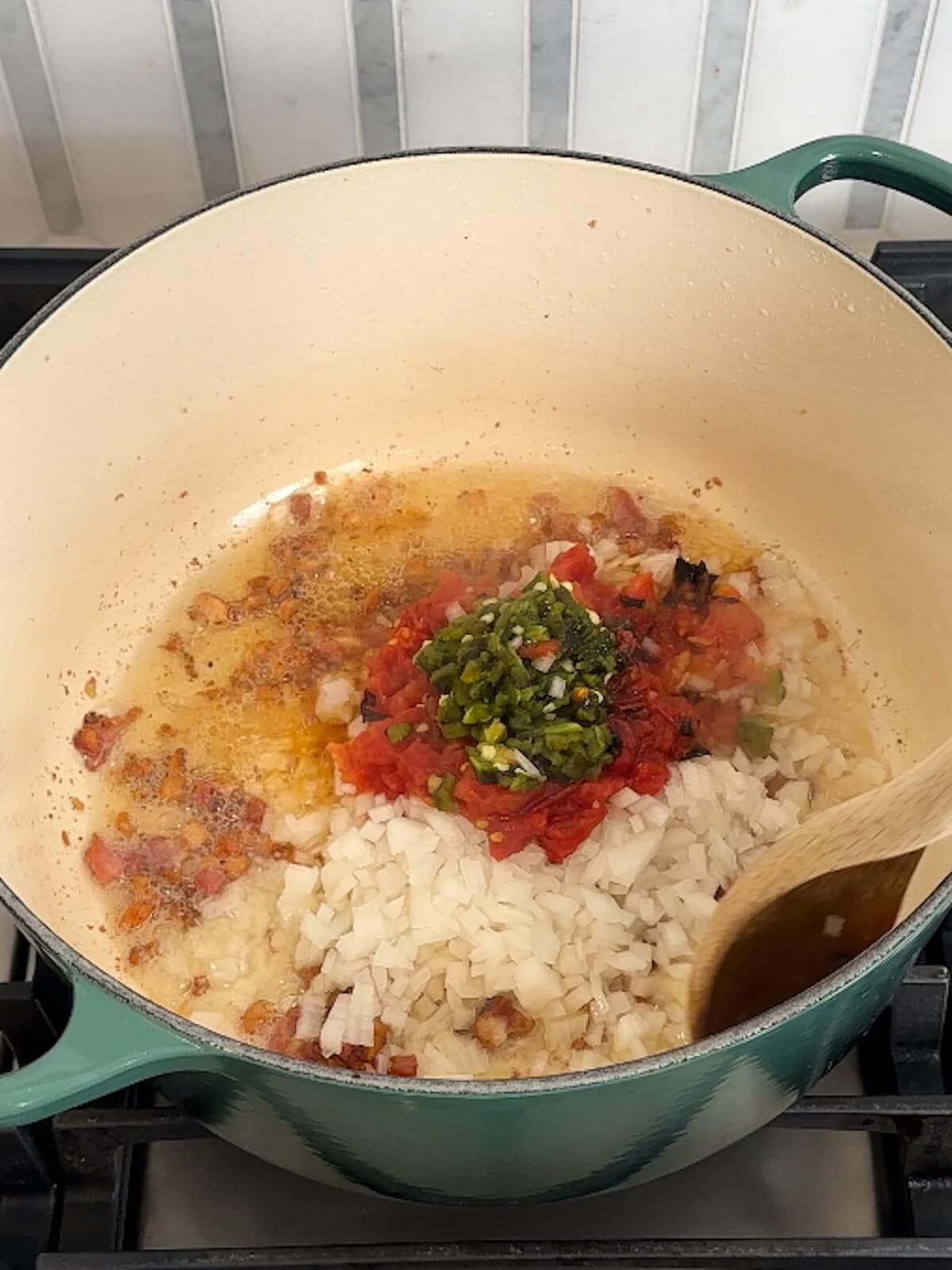 Sauteing aromatics in bacon and bacon fat in a dutch oven for charro beans.