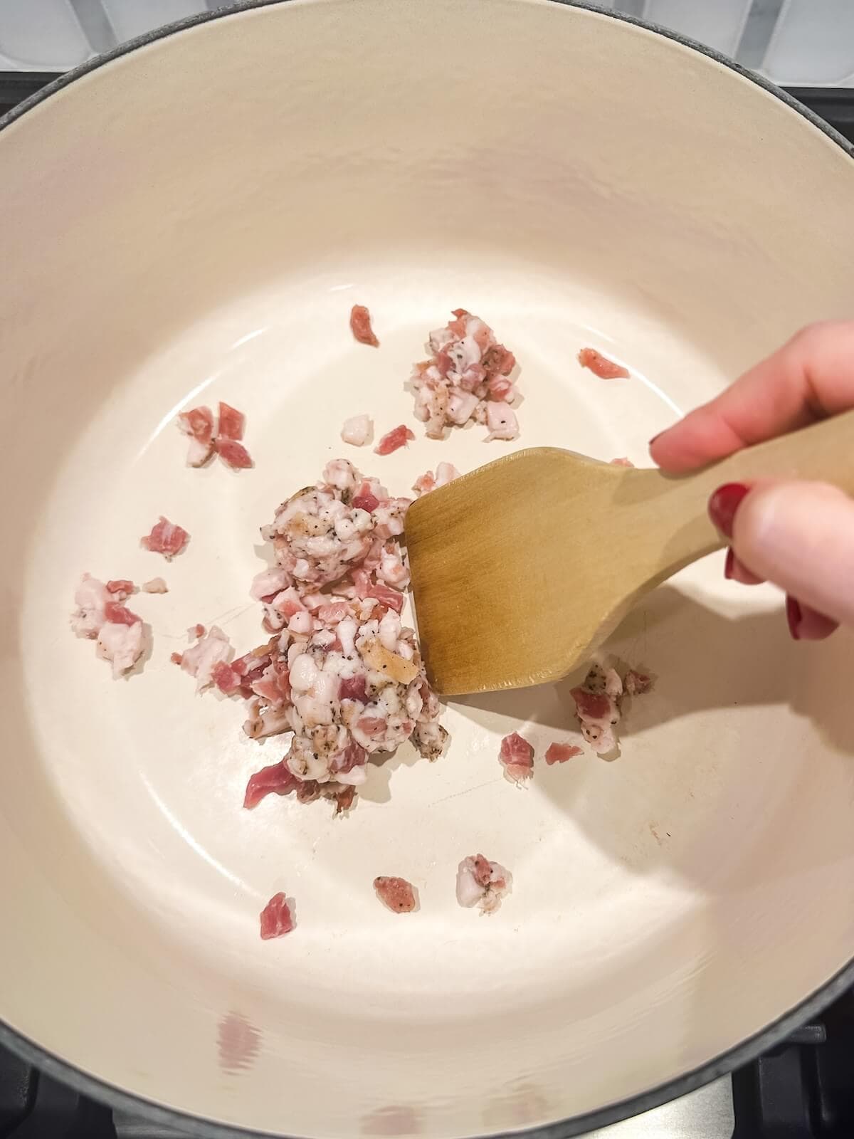 Cooking chopped bacon for charro beans in a dutch oven.