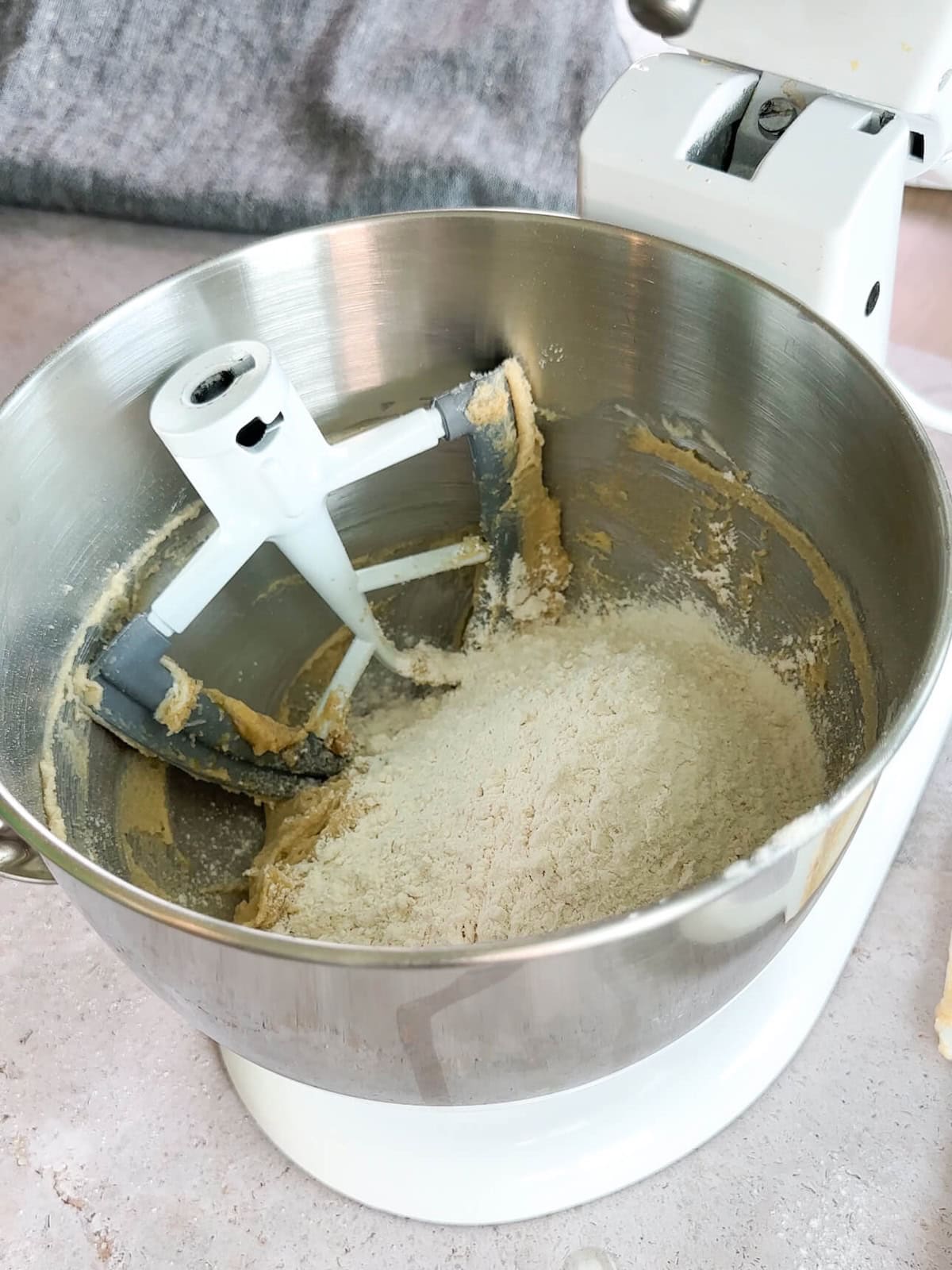 adding flour and leavening to cookie dough in mixer.