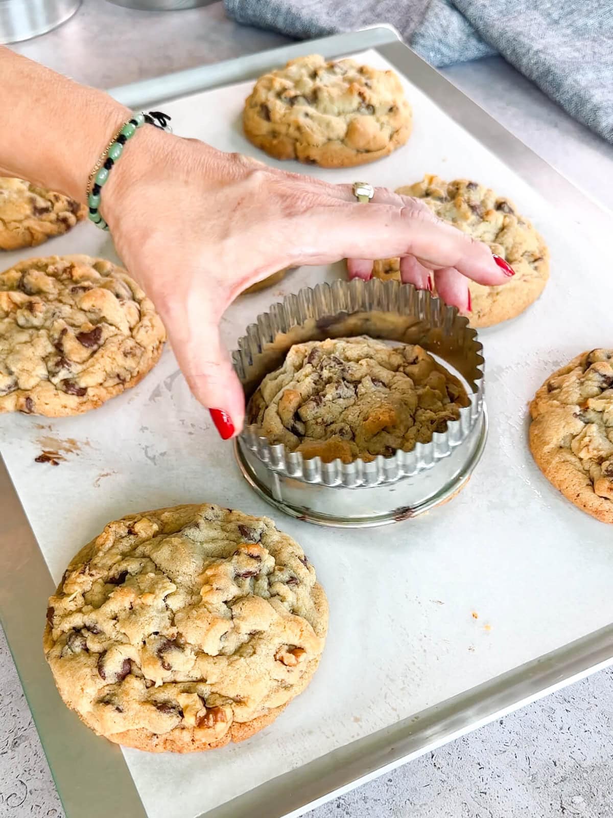 shaping hot baked cookies for a perfect edge.