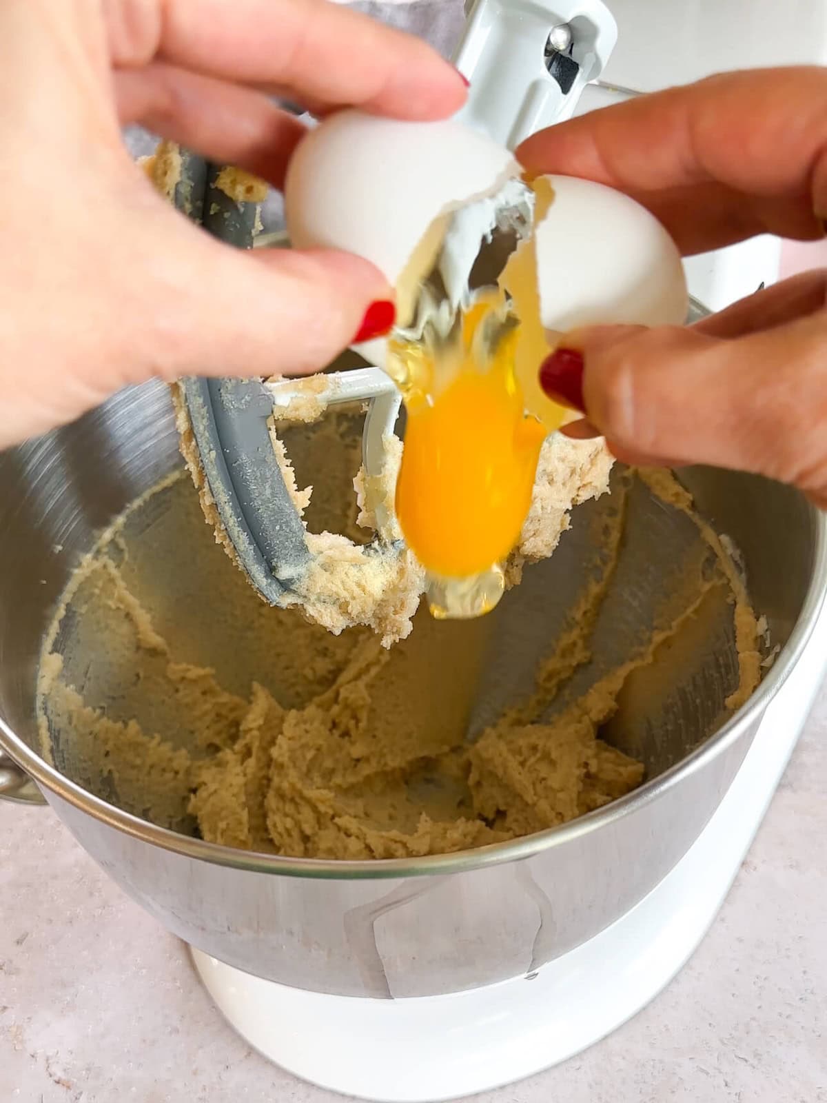 adding egg to batter of walnut chocolate chip cookies