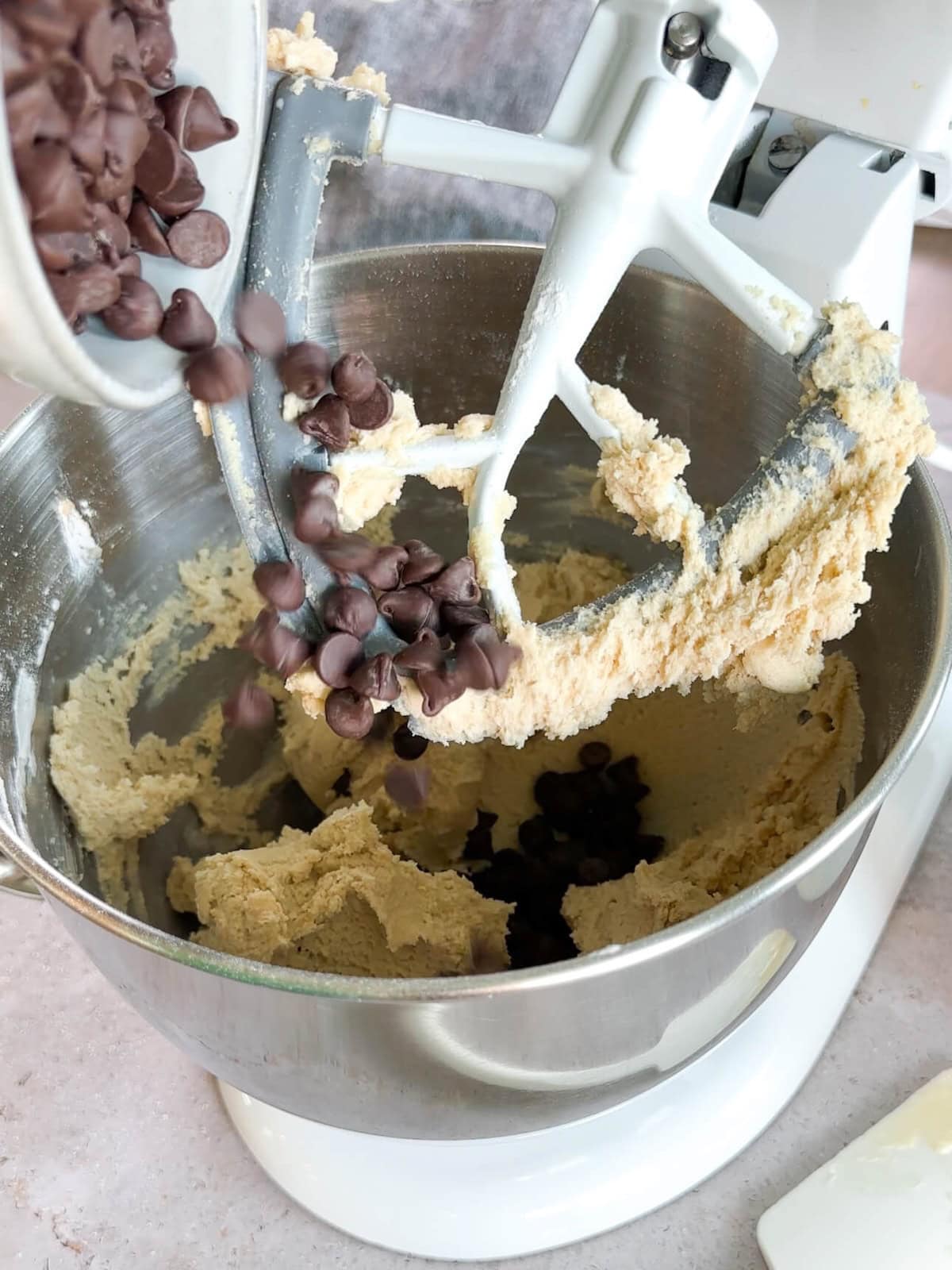 adding chocolate chips to walnut chocolate chip cookies dough