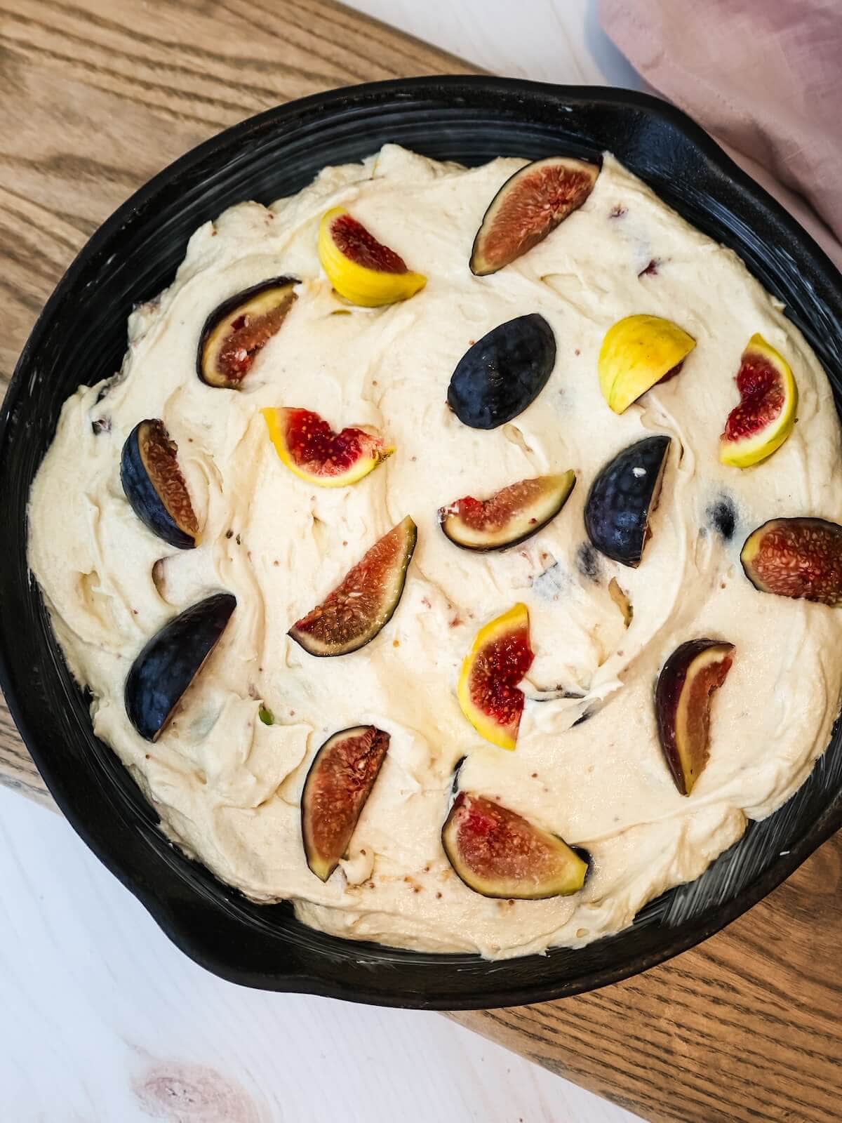 fig cake batter spread into pan with fresh figs on top.