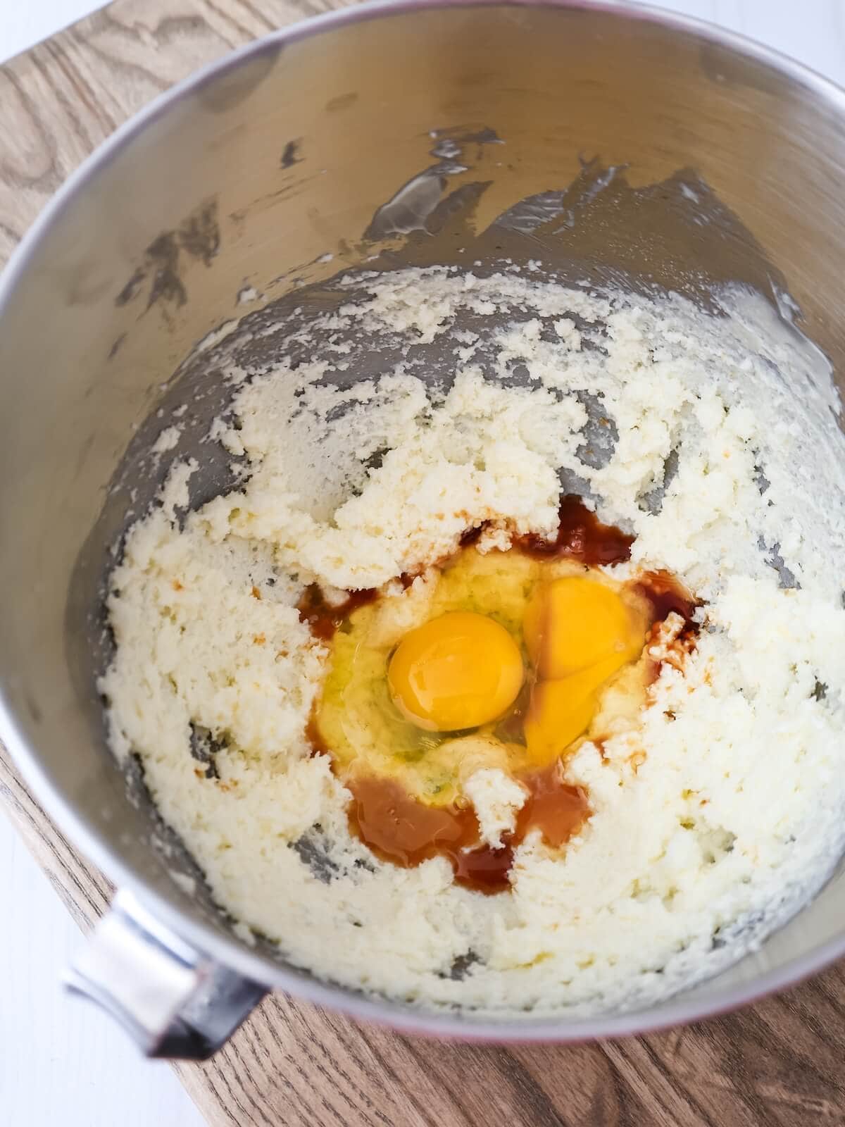mixing eggs and vanilla into creamed butter and sugar for fig cake.