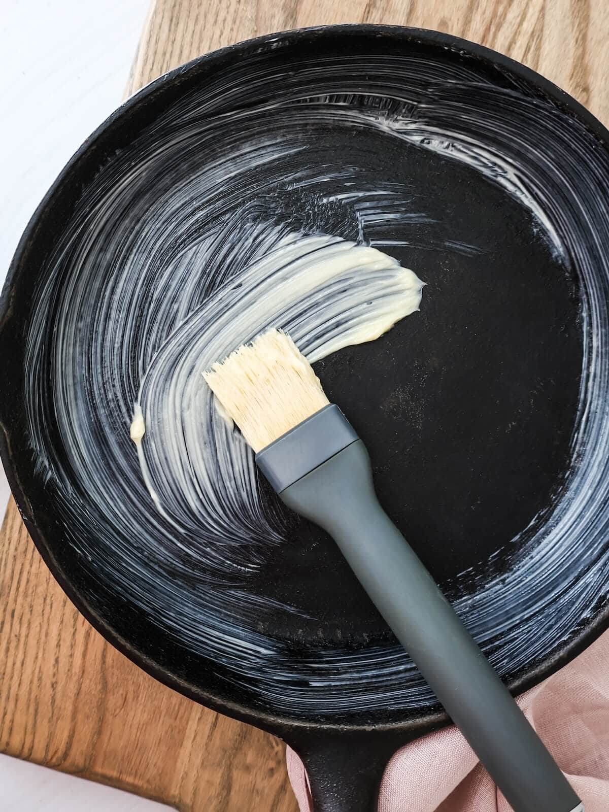 buttering pan for cake with a brush and soft butter.