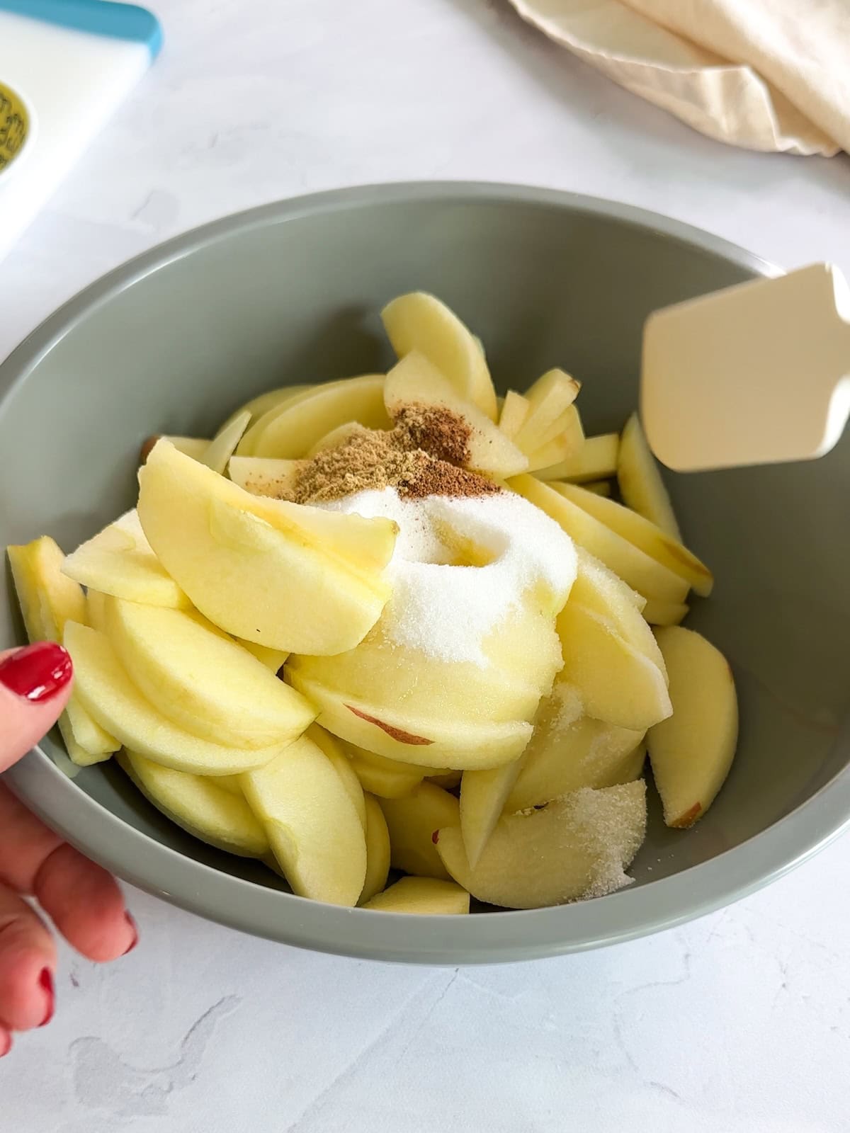 stirring sliced apples with sugar and spices for apple tart.