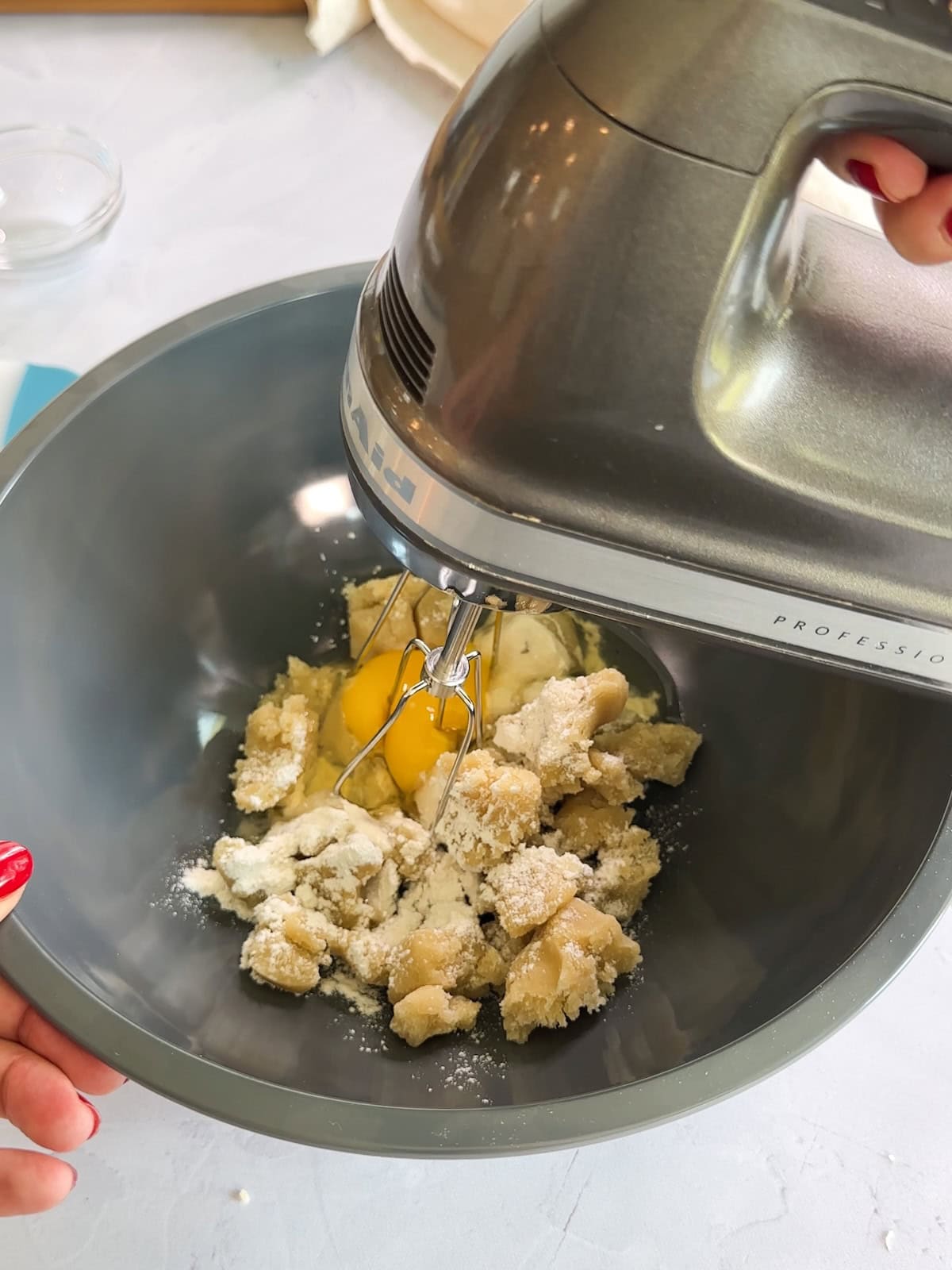 mixing almond paste, egg, and other ingredients in a bowl for frangipane.