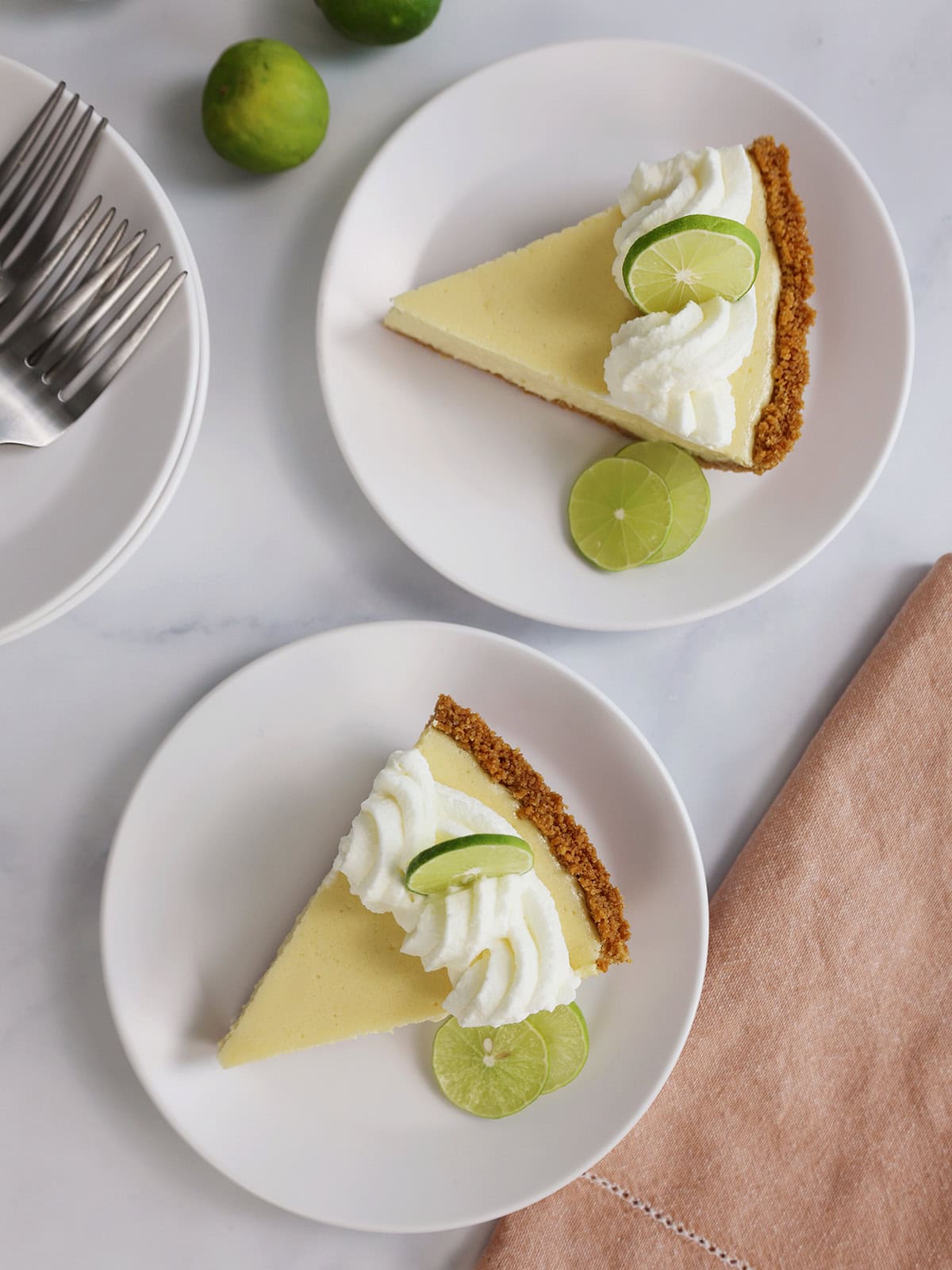 Two slices of key lime pie on small white plates.