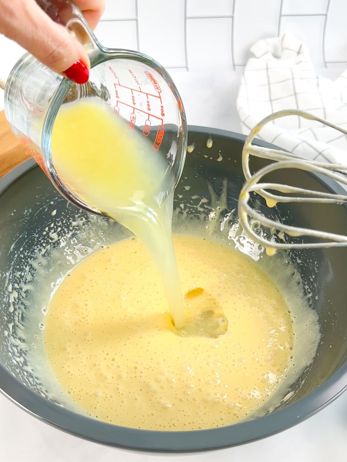 Adding lime juice to a lime bars filling.