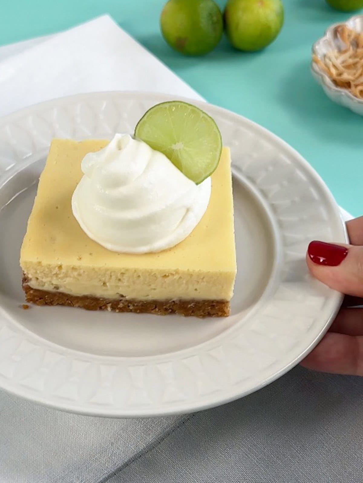 Finished key lime pie bars being served on a white plate.