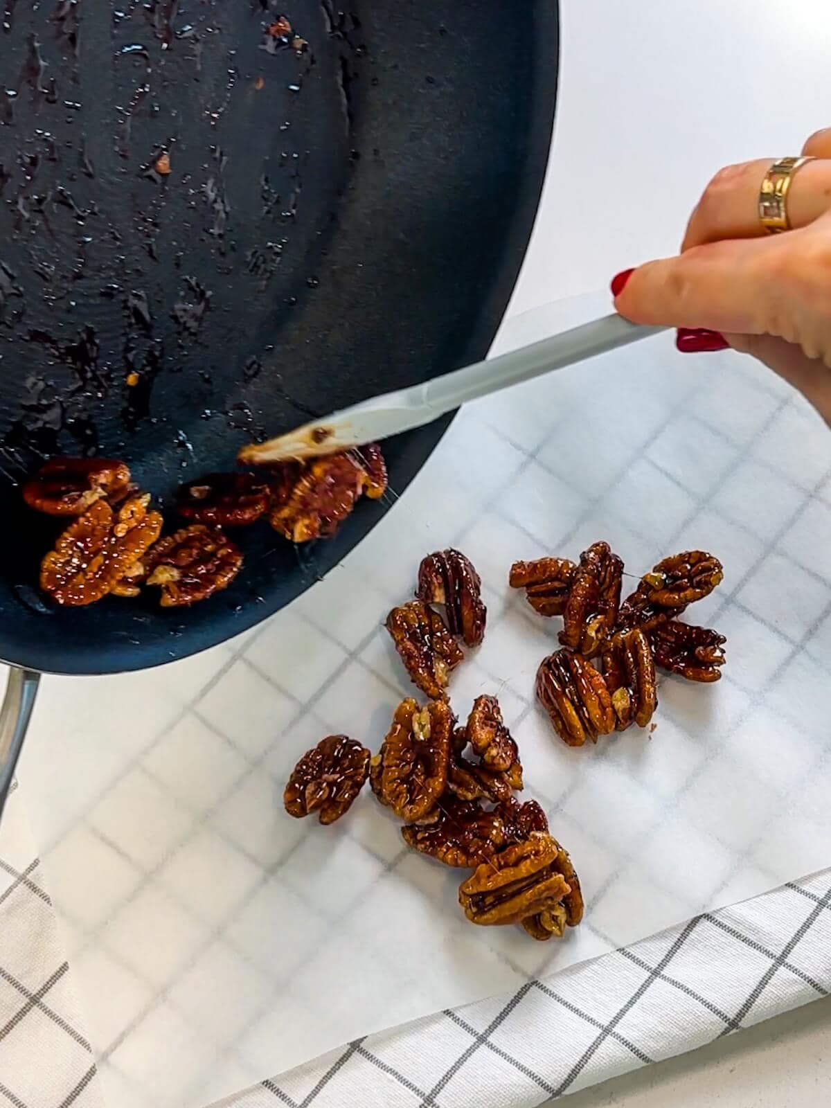 Cool candied pecans on a sheet of parchment paper.