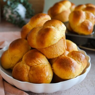 Close up of a white bowl filled with sweet potato rolls.