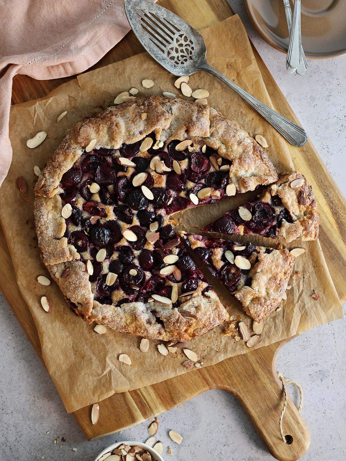 Top view of a cherry galette with two slices slightly removed.