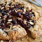 Close up of a cherry galette with two slices partially removed.