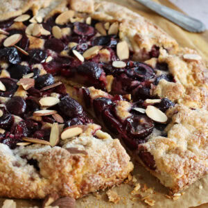 Close up of a cherry galette with two slices partially removed.