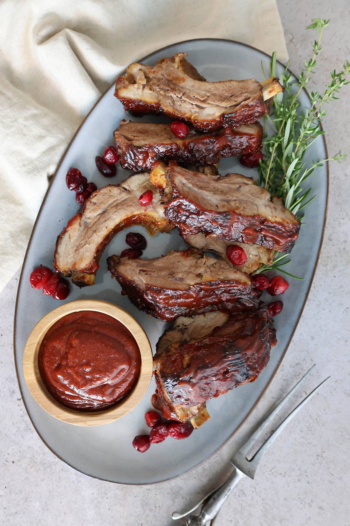 A platter of ribs topped with cranberry bbq sauce.
