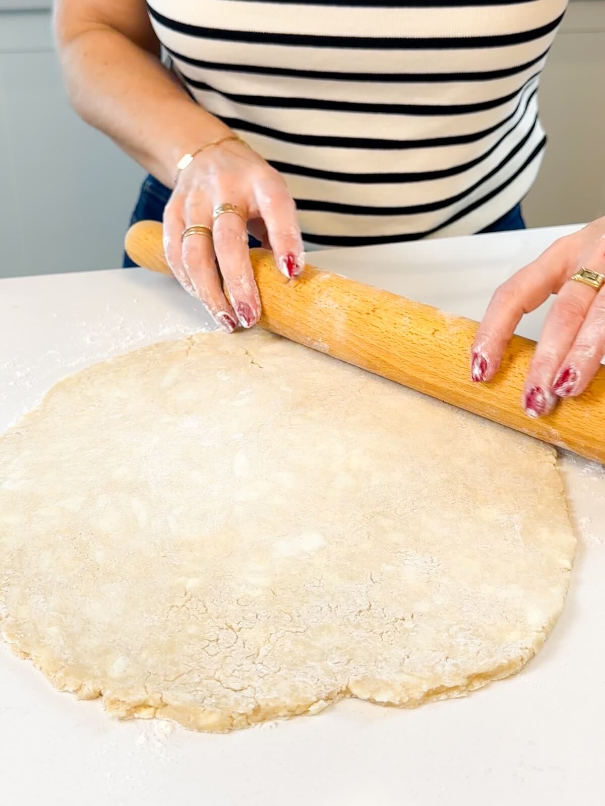 Hand rolling out pie dough.