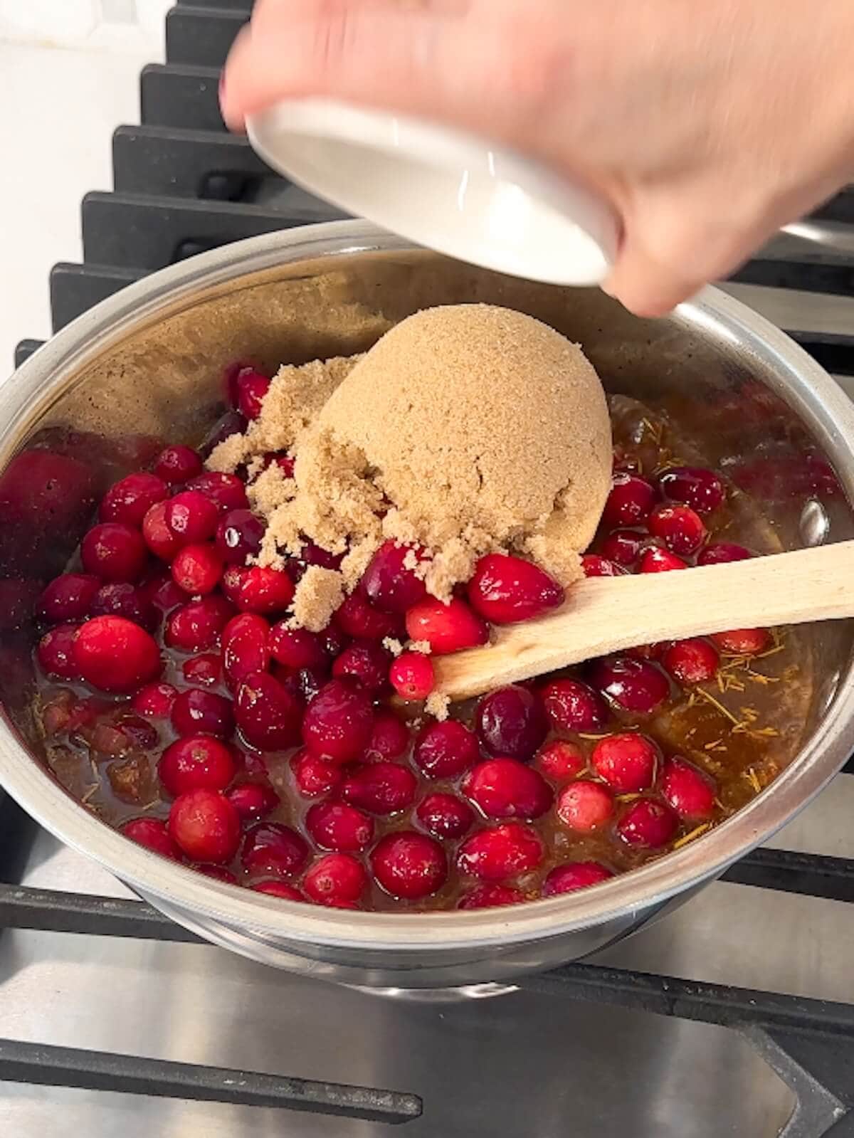Cranberries and bbq sauce mixed in a bowl with other bbq sauce ingredients.
