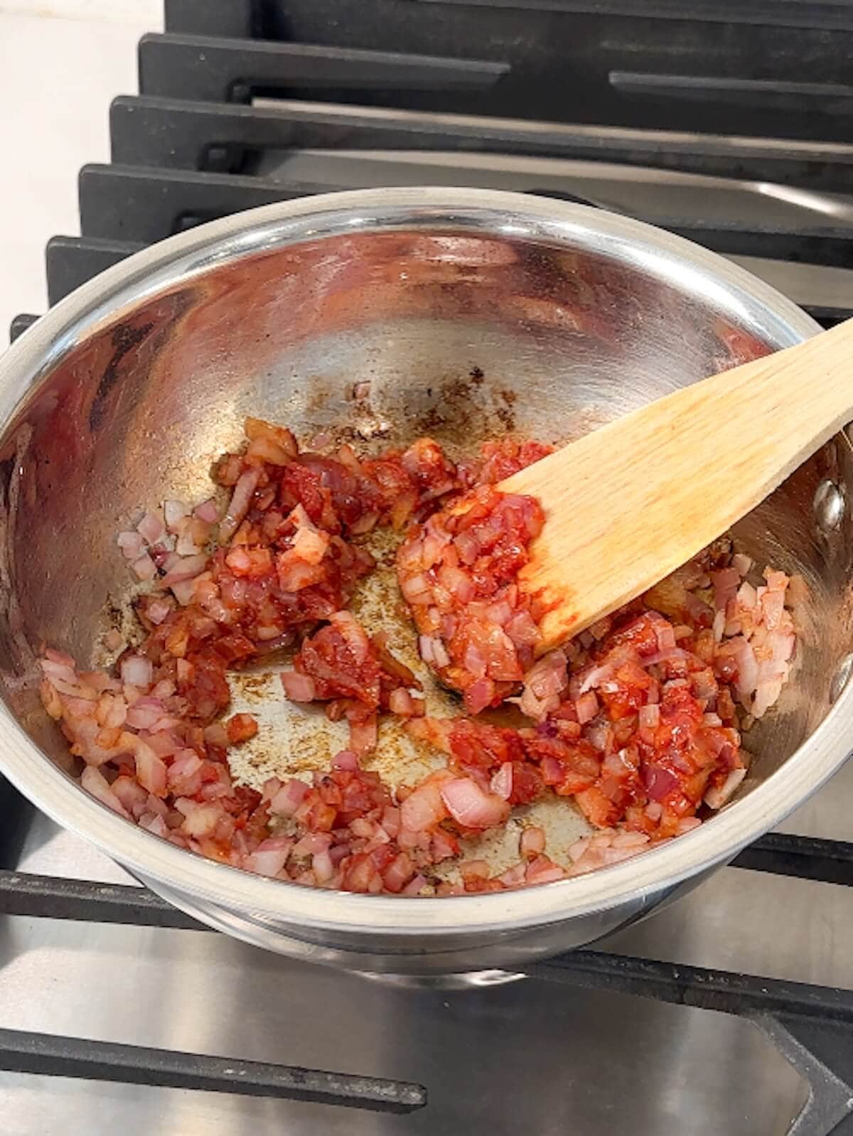 Onions and tomato sauce mixed in a bowl.