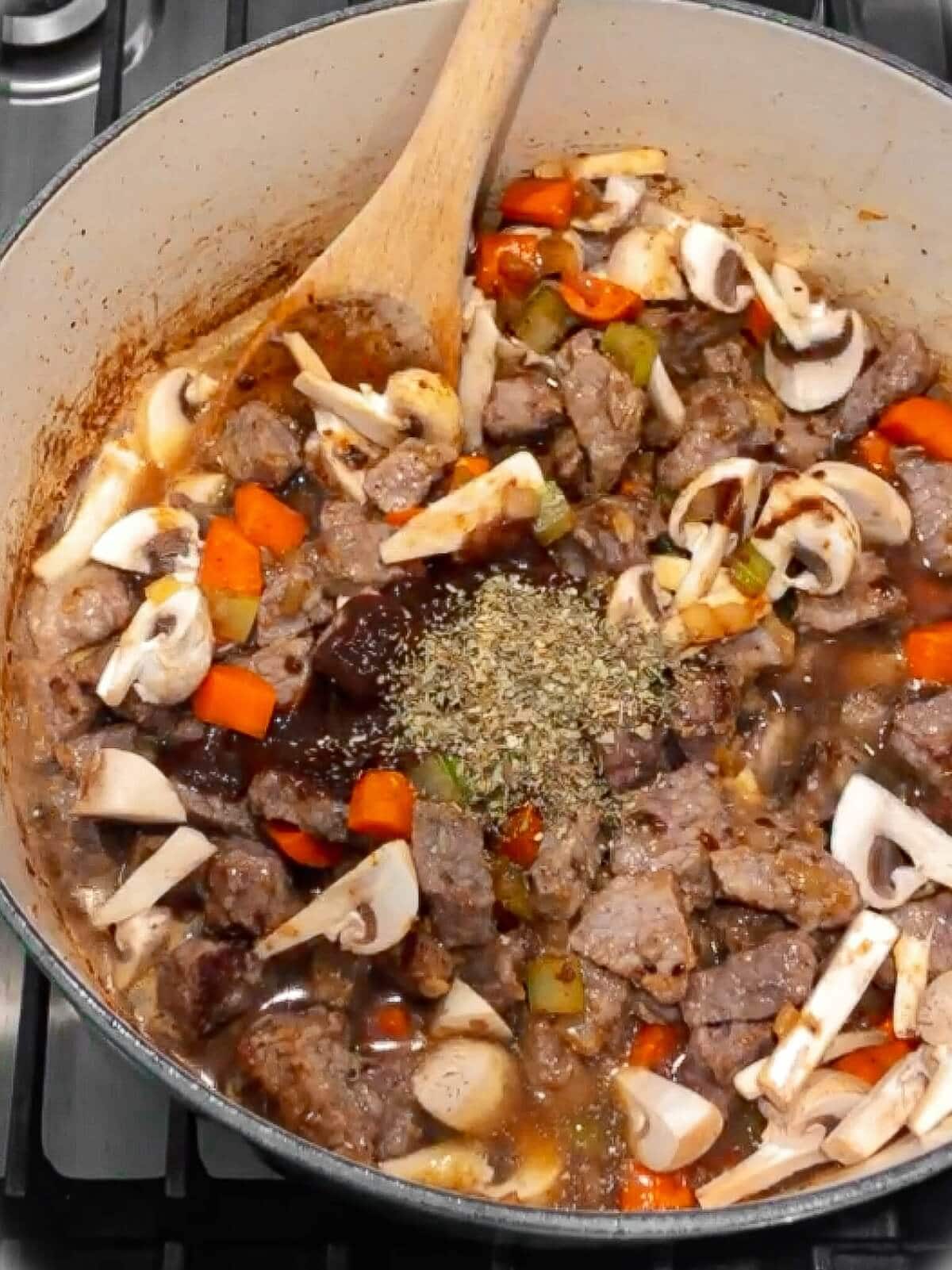 Combining all stew ingredients in a pot for beef stew.